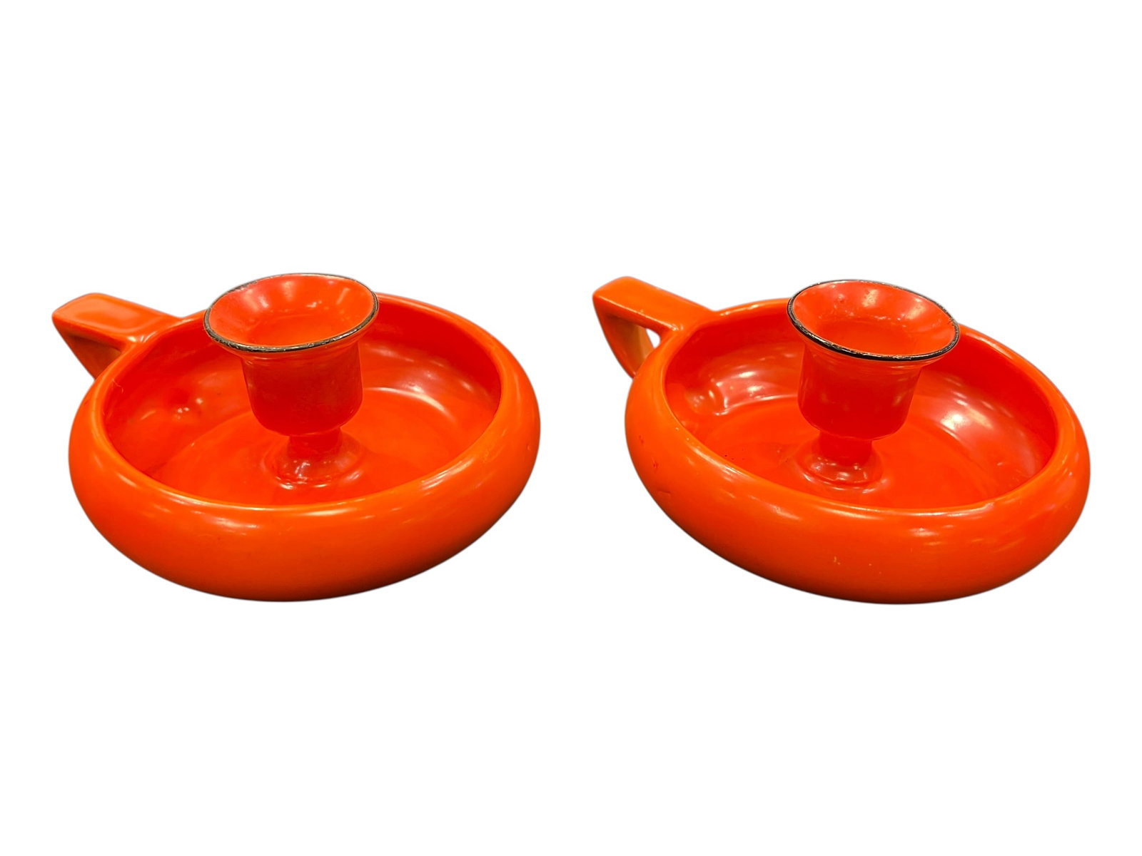 vintage orange enamel chamberstick candle holders: These items are vintage orange enamel chamberstick candle holders, likely manufactured in Europe (such as by Neerlandia) during the 1950s or 1960s. [1, 2]Key FeaturesDesign Style: They feature a class