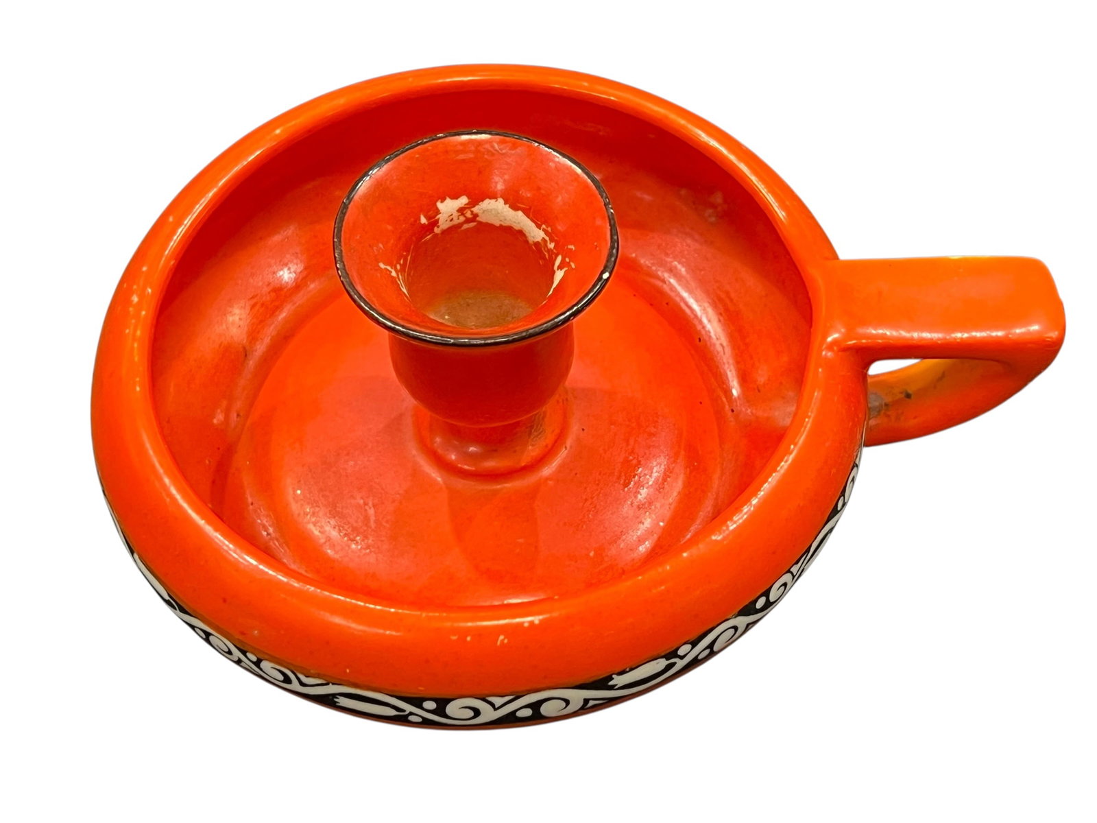 chamberstick candle holder,: This object is a vintage ceramic chamberstick candle holder, recognizable by its signature low profile, wide drip tray, and integrated loop handle. Historically, these portable candle holders were car