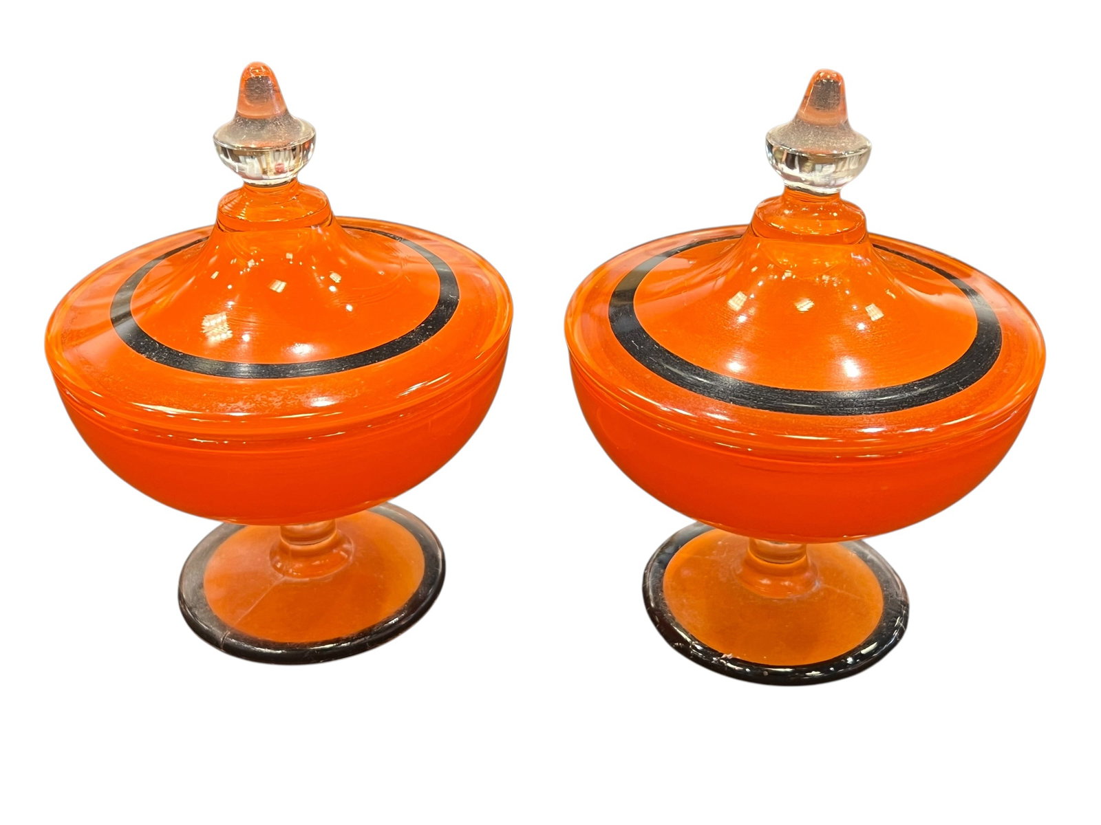 vintage Bohemian Art Deco "Tango" glass lidded candy dishes: These striking vessels are vintage Bohemian Art Deco "Tango" glass lidded candy dishes, manufactured circa 1915–1930. This specific style features a vibrant orange monocolor base contrasted with a b