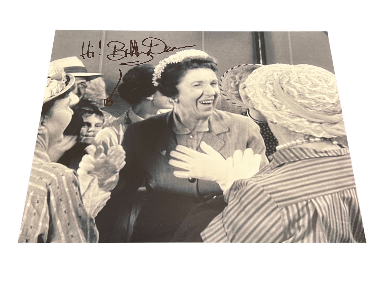 Signed Photograph: This image appears to be a vintage black and white press photograph from the 1960s. [1]The photo shows a group of women, including one identified as Mrs. Chun Parsons, likely at a social event or