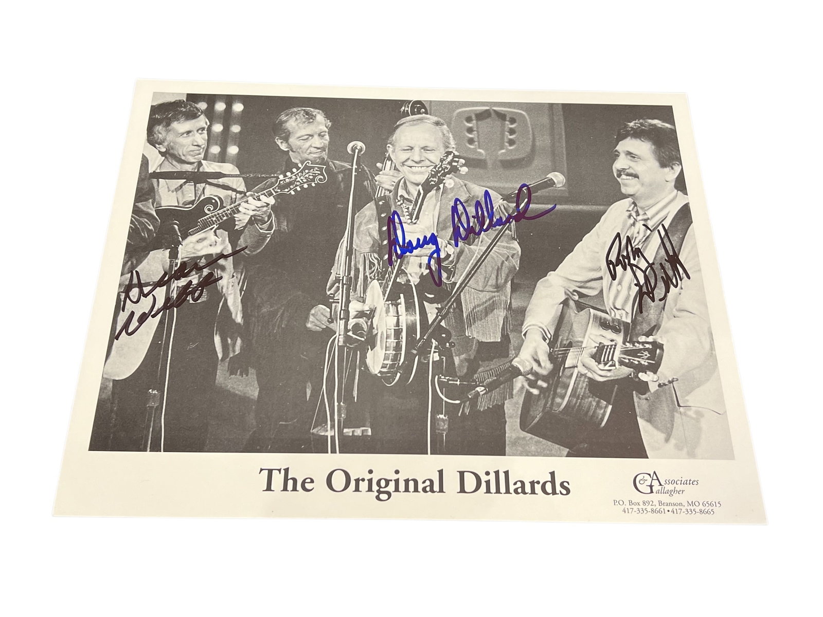 Signed Doug Dillard Photograph: This is an 8x10 semi-glossy cardstock photo of The Dillards, a pioneering bluegrass band.The photo appears to be signed by all four original members: Dean Webb, Mitch Jayne, Doug Dillard, and Rodney
