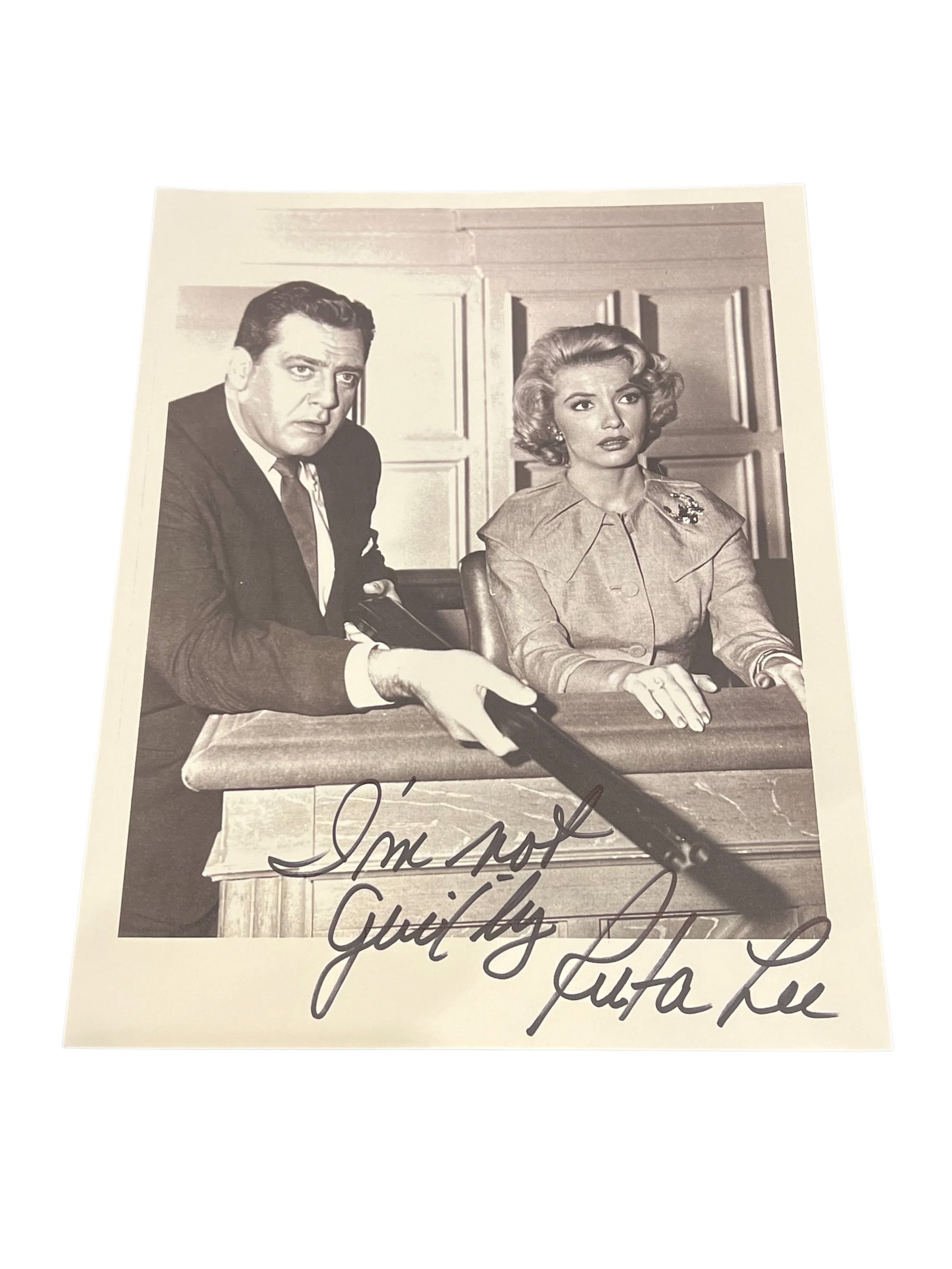 Signed Ruta Lee Photograph: This is a vintage photograph featuring actors Raymond Burr and Ruta Lee from a 1960 episode of the television series Perry Mason. [1, 2]Raymond Burr starred as defense attorney Perry Mason in this