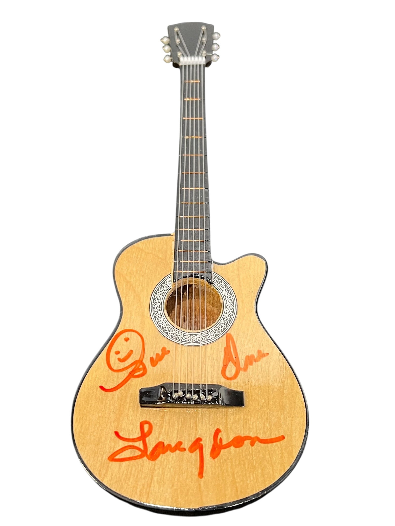 Signed Miniature Acoustic Guitar: The image features a miniature acoustic guitar collectible featuring orange-colored hand-signed autographs on its body. The prominent signature across the lower half reads "Langdon" alongside a drawn