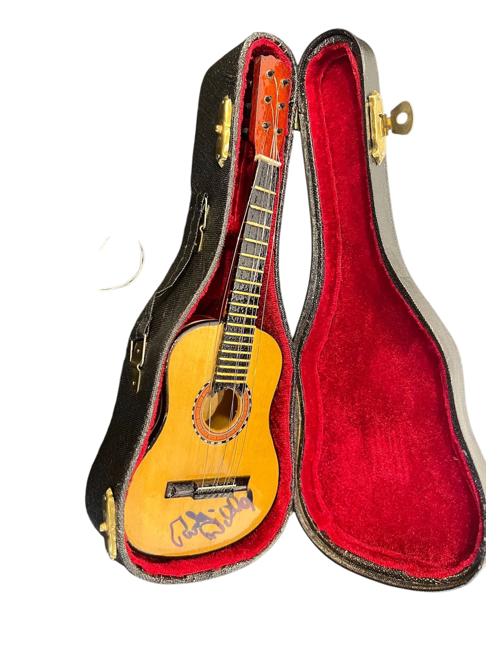 Signed Miniature Acoustic Guitar: This item is a decorative miniature acoustic guitar replica, complete with a velvet-lined hardshell display case. While it mirrors the anatomy of a genuine classical guitar, it is structurally