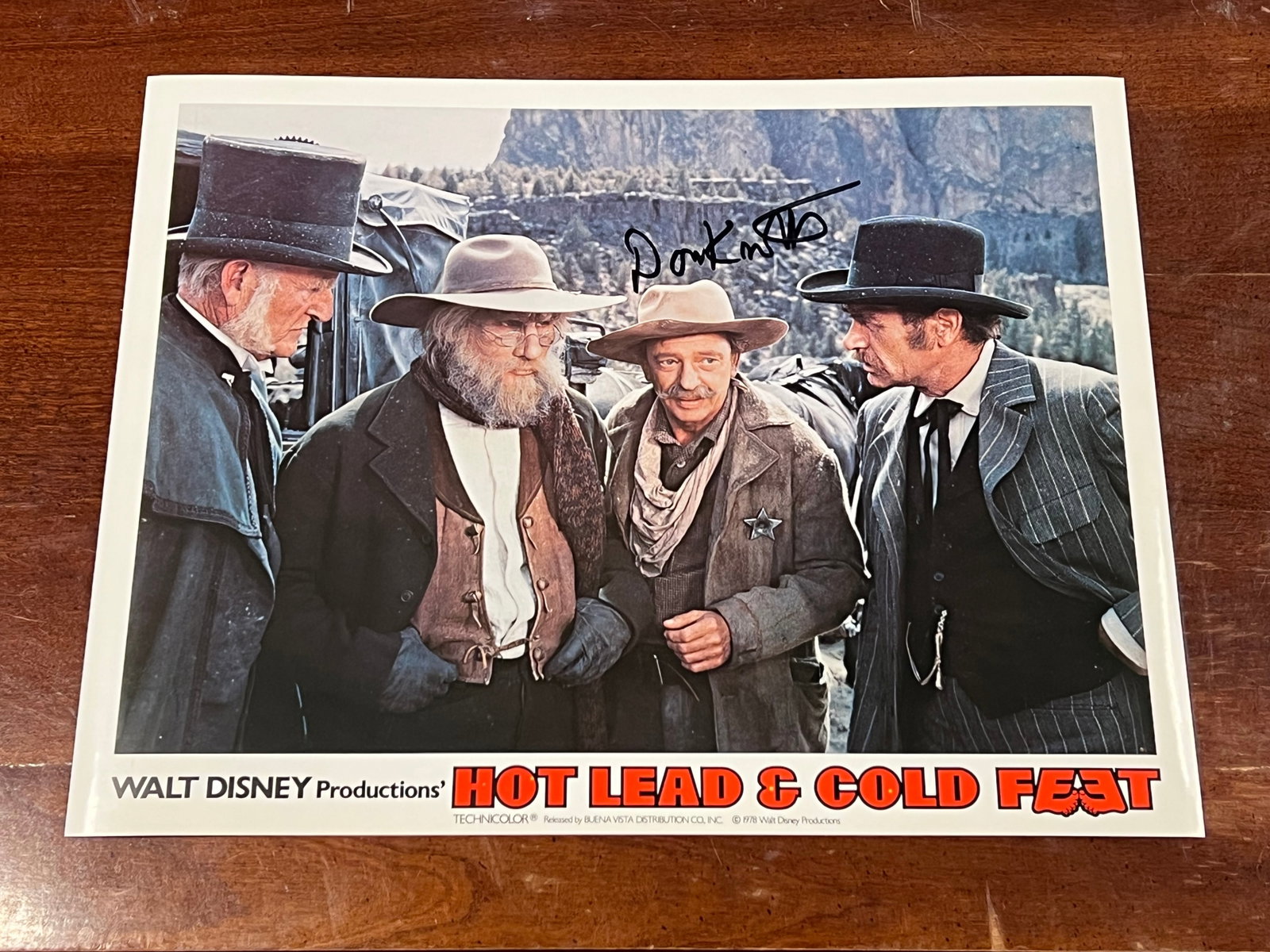Autographed “Hot Lead and Cold Feet" Lobby Card: This image is an original 11"x14" color lobby card from the 1978 Disney film Hot Lead & Cold Feet. [1, 2]It features actors Don Knotts, Darren McGavin, Jim Dale, and Jack Elam.The lobby card shows a s