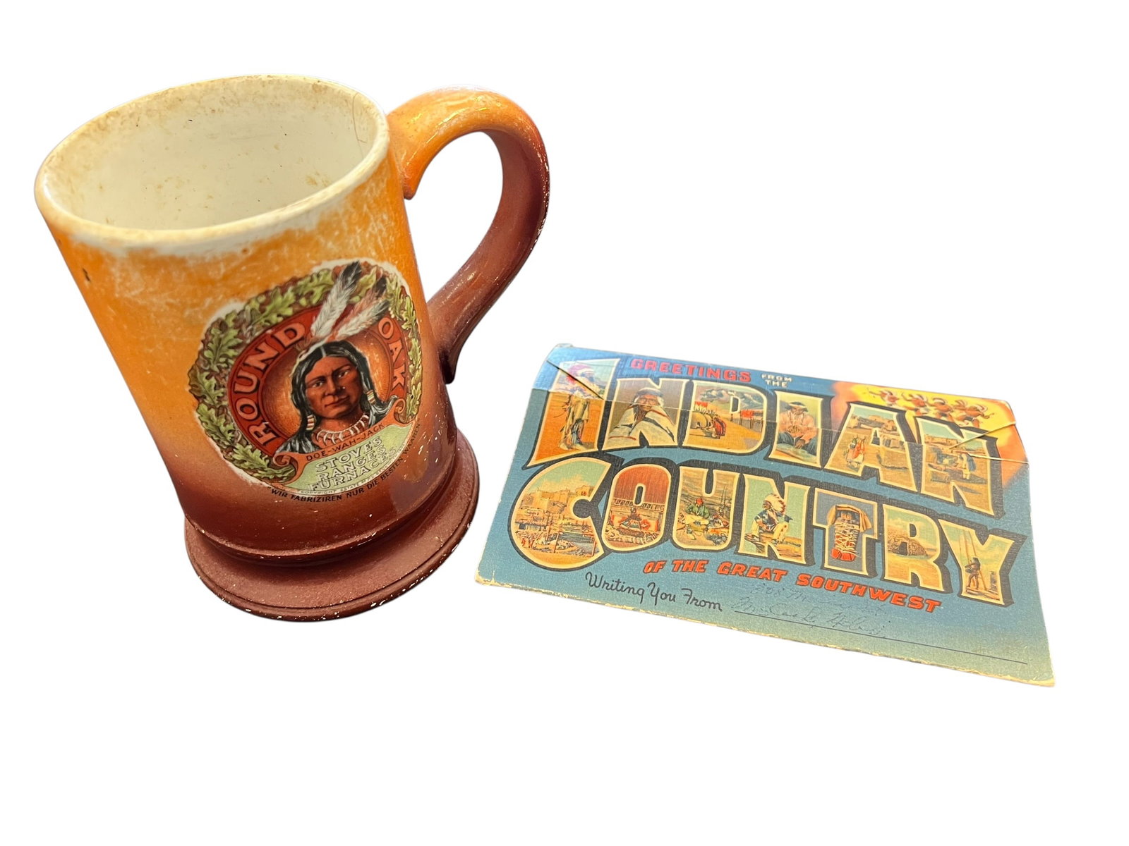 Native American Ceramic Mug: This is an antique 1907 ceramic advertising mug for Round Oak Stoves, Ranges, and Furnaces. [1, 2]The mug features a graphic of the Doe-Wah-Jack Native American figure, associated with the manufacture