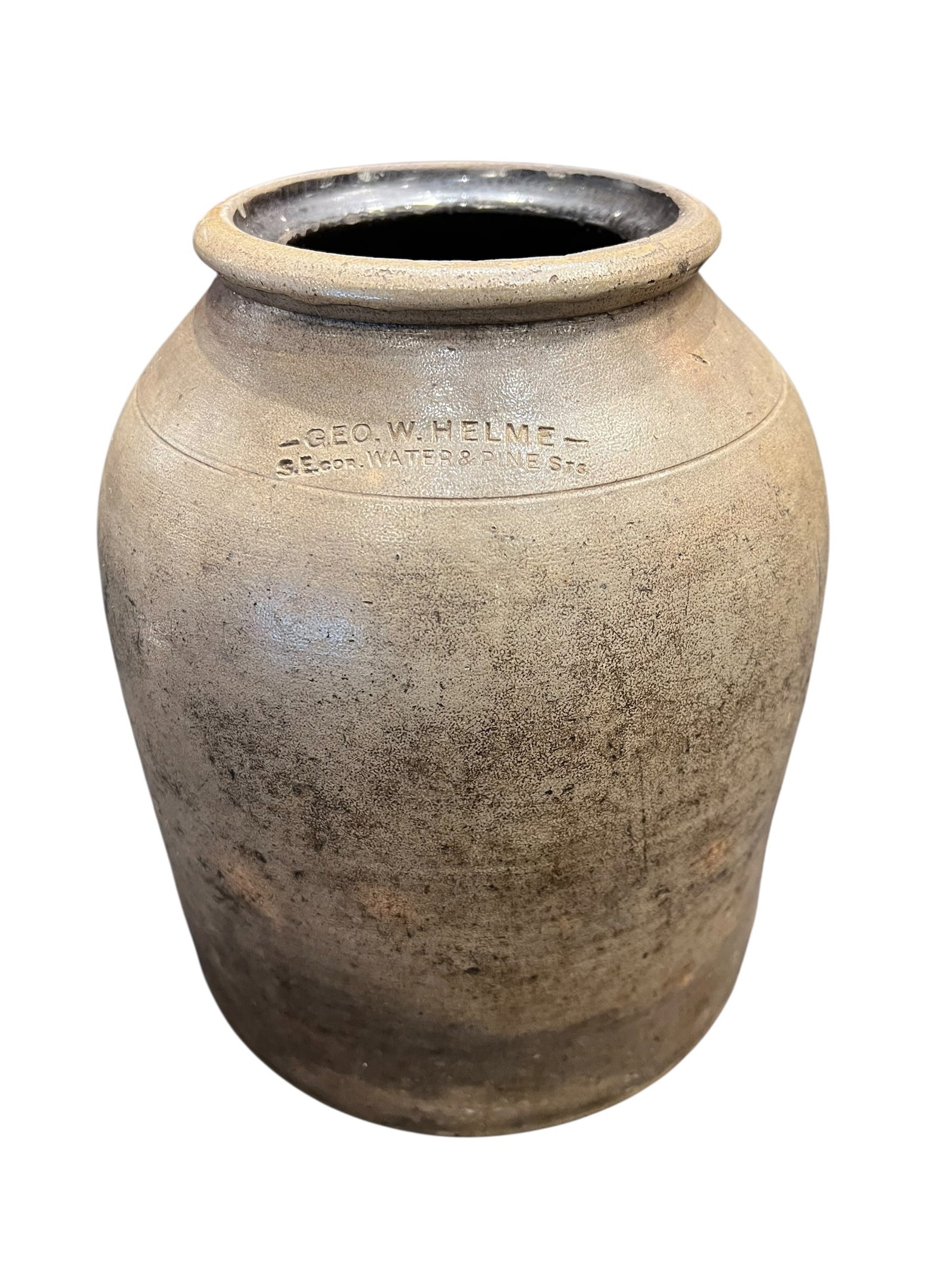 2 Gallon Stoneware Crock: This is an antique stoneware crock, likely used for preserving food or storing liquids, featuring an impressed mark for "GEO. W. HELME" and a specific corner address.Stoneware vessels like this one we