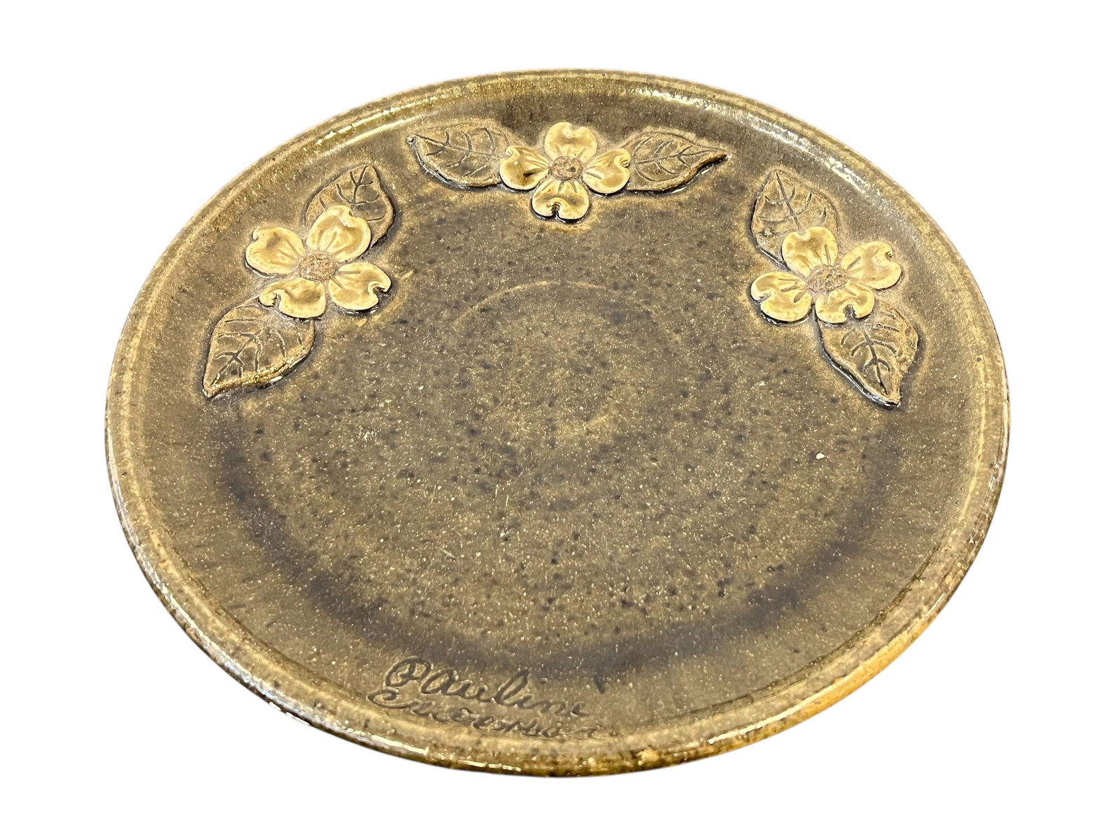 Dogwood Stoneware Plate by Pauline Crocker: This is a handcrafted dogwood stoneware plate made by folk artist Pauline Crocker. [1]Key CharacteristicsArtist: Hand-signed at the bottom rim by artist Pauline Crocker. Along with her husband