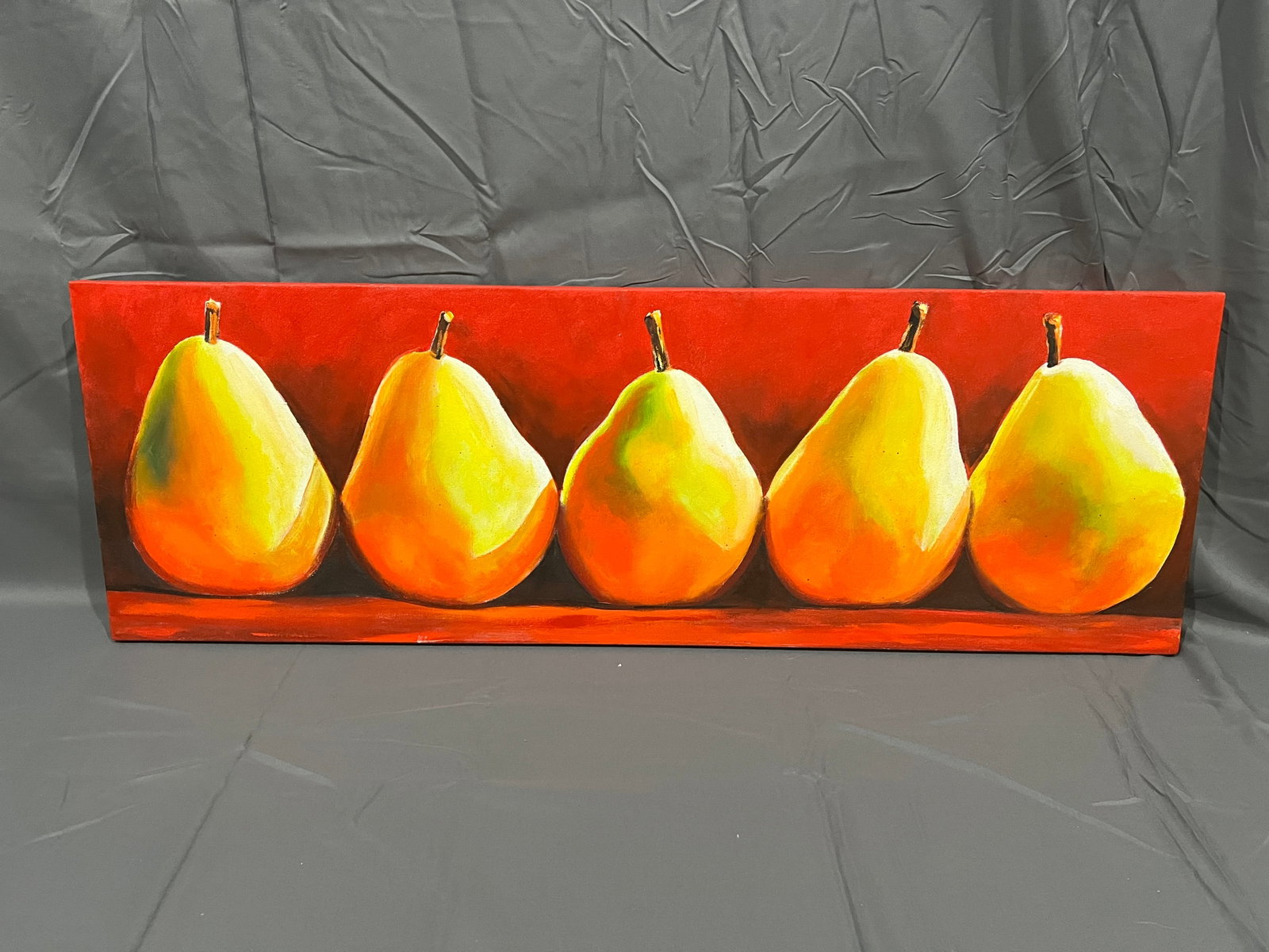 39Painting Gang of Pearsa: The artwork in the image is a contemporary panoramic still life painting titled "Green Pears on Red" by artist Toni Grote.Artwork OverviewComposition: Features a row of five vibrant yellow-green