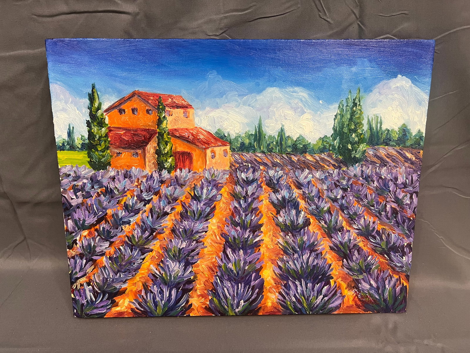 147Signed Carrie Setter Oil on Canvas - Landscape Scene: This painting portrays a vibrant, sun-drenched landscape featuring a rustic Tuscan or Provençal farmhouse framed by towering cypress trees and an expansive field of blooming lavender. The artwork