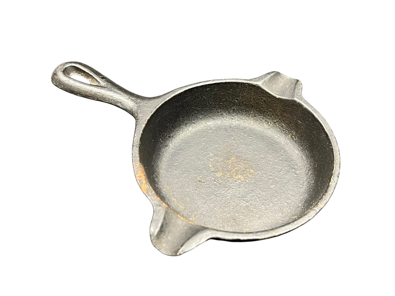 Wagnerware Small Cast Iron Skillet: The image shows a miniature cast iron novelty piece, specifically a vintage Lodge 01AT Cast Iron Skillet / Ashtray, which measures about 3 to 5 inches across and features dual side notches originally