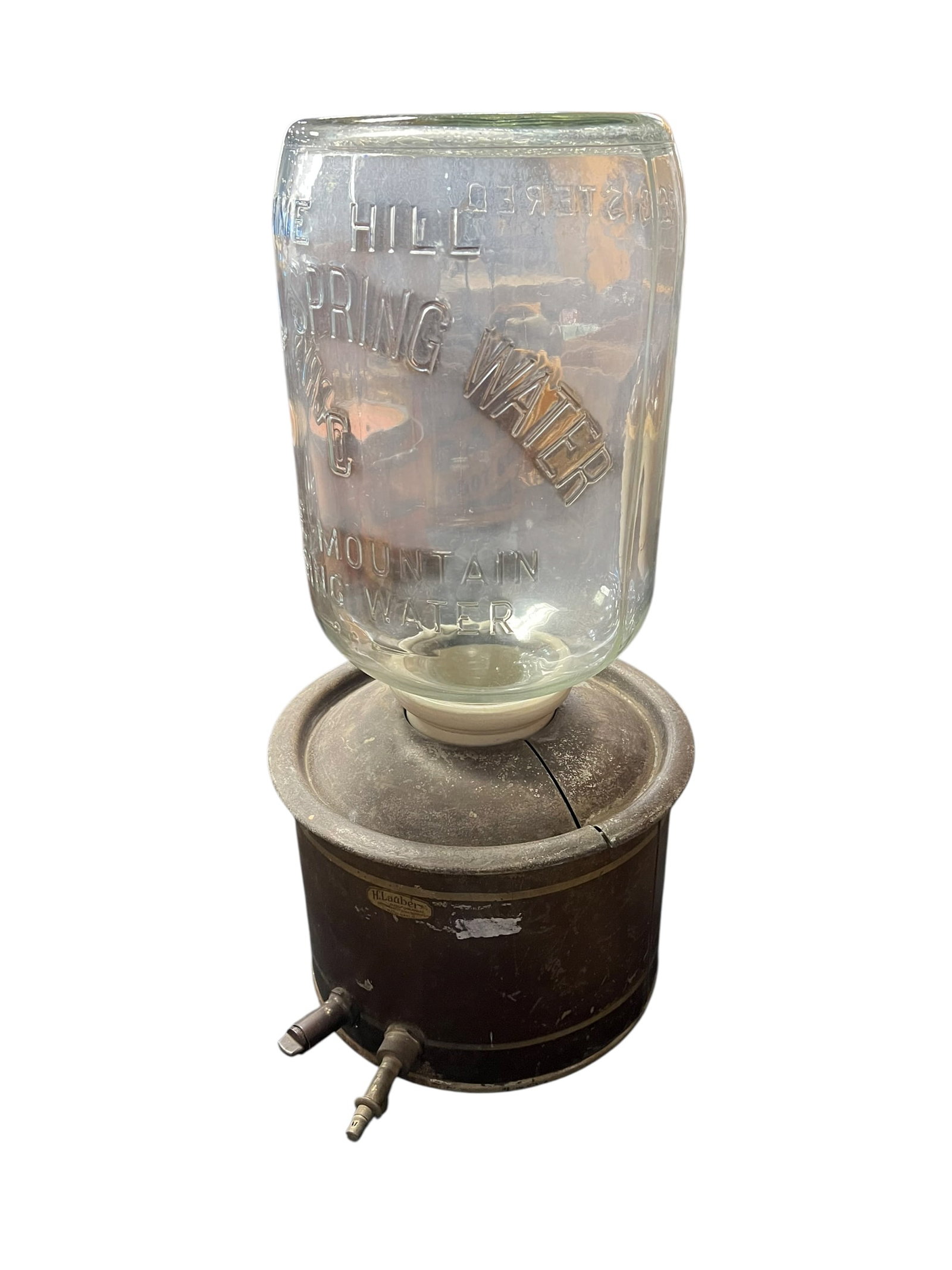 Crystal Springs Water Water Cooler: The selected region features an antique 5-gallon "Pine Hill Crystal Spring Mountain Water" embossed glass bottle inverted on a vintage metal water cooler dispenser stand with brass spigots. [1, 2]Top 