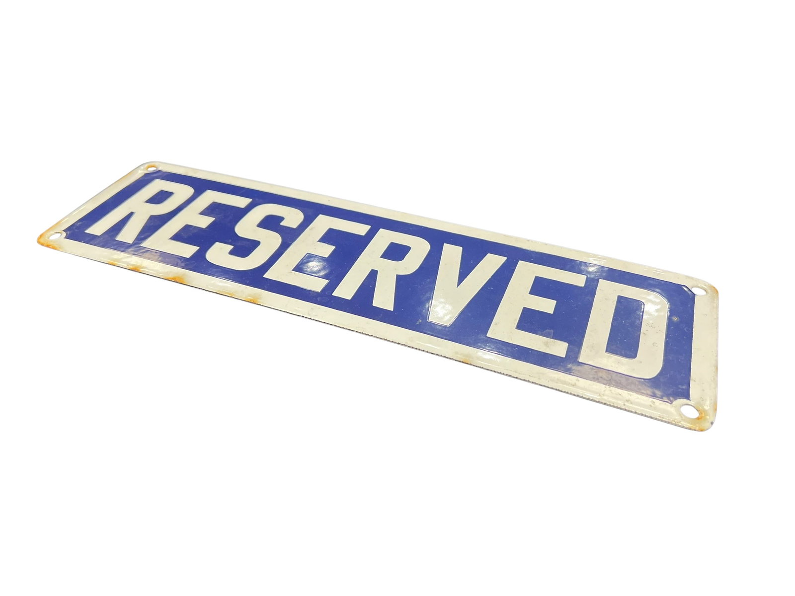 Reserved Porcelain Sign: The image shows a vintage porcelain enamel "Reserved" sign featuring bold white block letters set against a deep blue rectangular background with weathered, rust-accented mounting holes at the