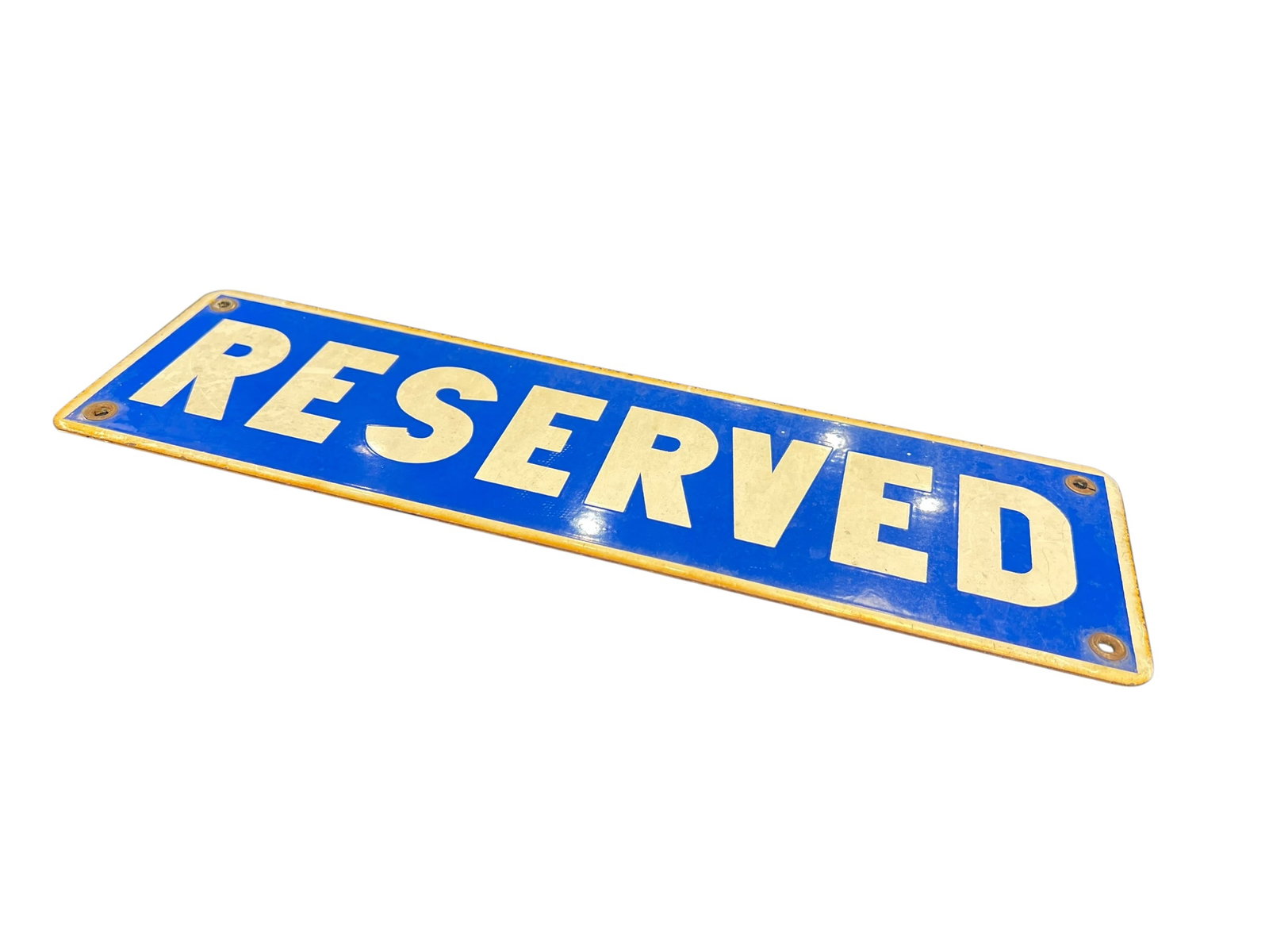 Reserved Porcelain Sign: The image shows a vintage painted metal or tin tacker "Reserved" sign featuring white block lettering against a blue background with a gold-toned border and corner screw holes. [1]Sign DetailsType:
