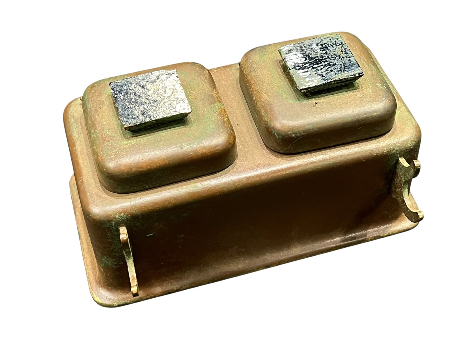 Copper-plated or Brass Double-well Rectangular Ink Stand: This object is an antique double desk inkwell featuring a heavy brass or bronze body with natural aged patina and tarnish. [1]The piece includes a rectangular main reservoir base and two distinct squa