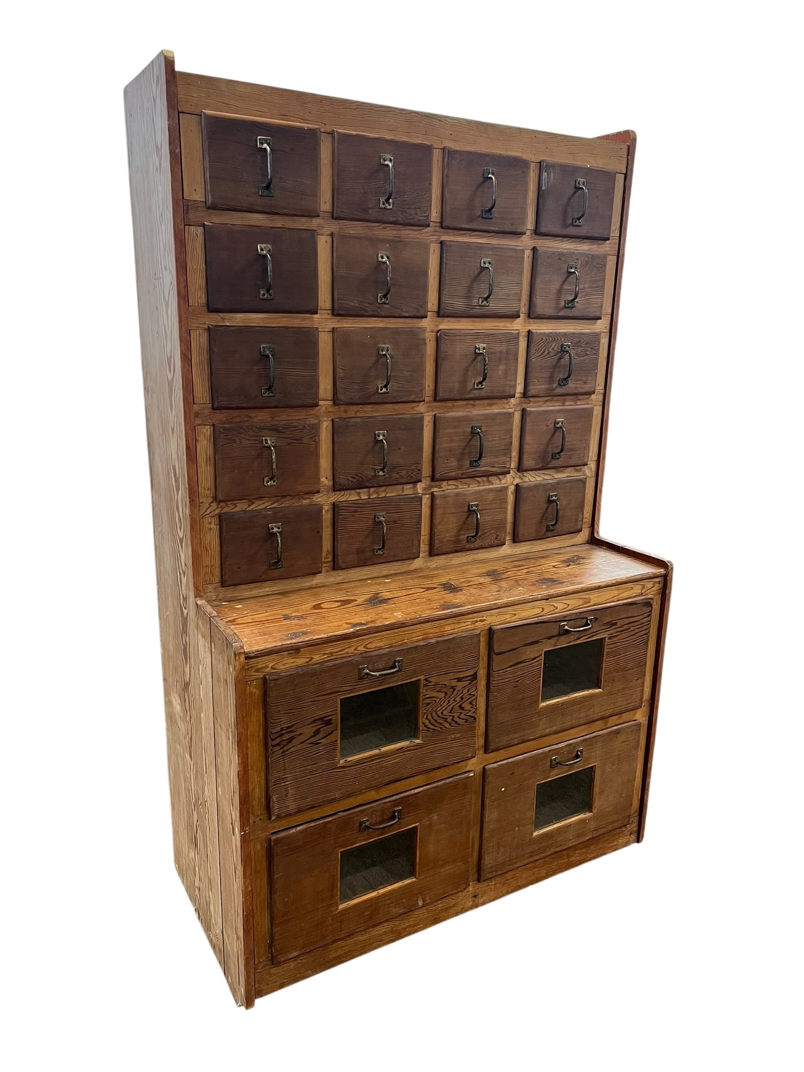 Early pine apothecary cabinet w/seed bin drawers.: This vintage wooden step-back apothecary and store counter cabinet features an upper section with twenty small drawers and a lower base with four large bin drawers inset with glass viewing panes.Upper