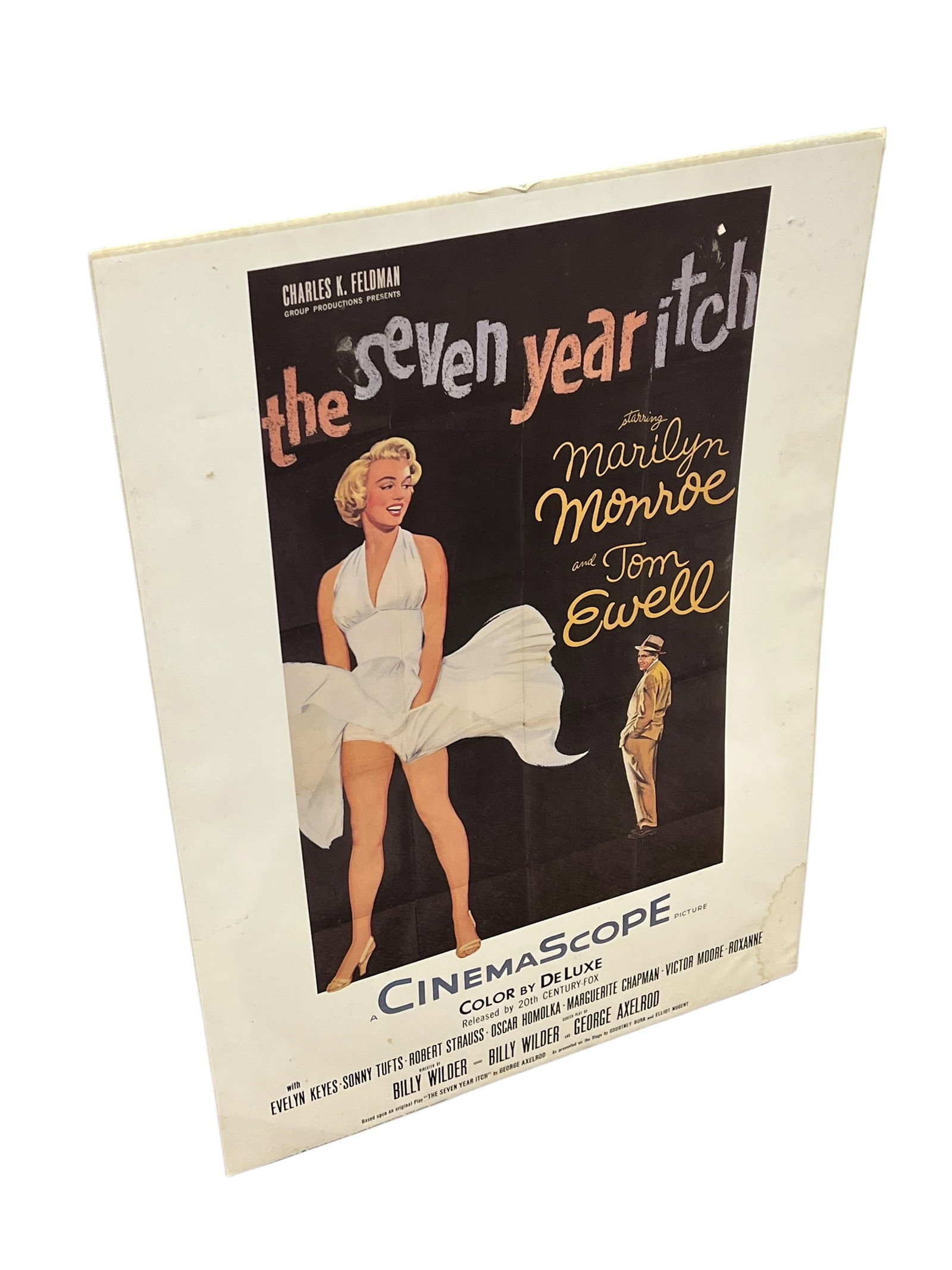 The Seven Year Itch Movie Advertising Poster: This image shows a vintage-style promotional poster for the 1955 romantic comedy film The Seven Year Itch, directed by Billy Wilder and starring Marilyn Monroe and Tom Ewell. [1]Film Details: