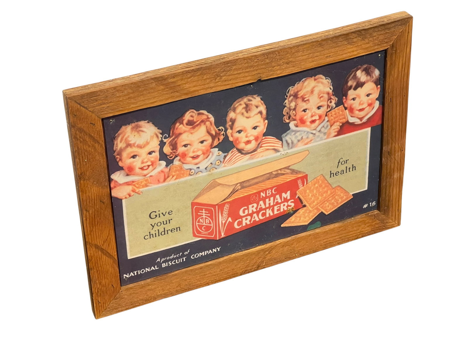 NBC Graham Cracker Advertising Sign: This item is a vintage-style decorative wall sign featuring classic National Biscuit Company (NBC) Graham Crackers advertising matted in a wooden frame. [1]Design: Displays vintage artwork of smiling
