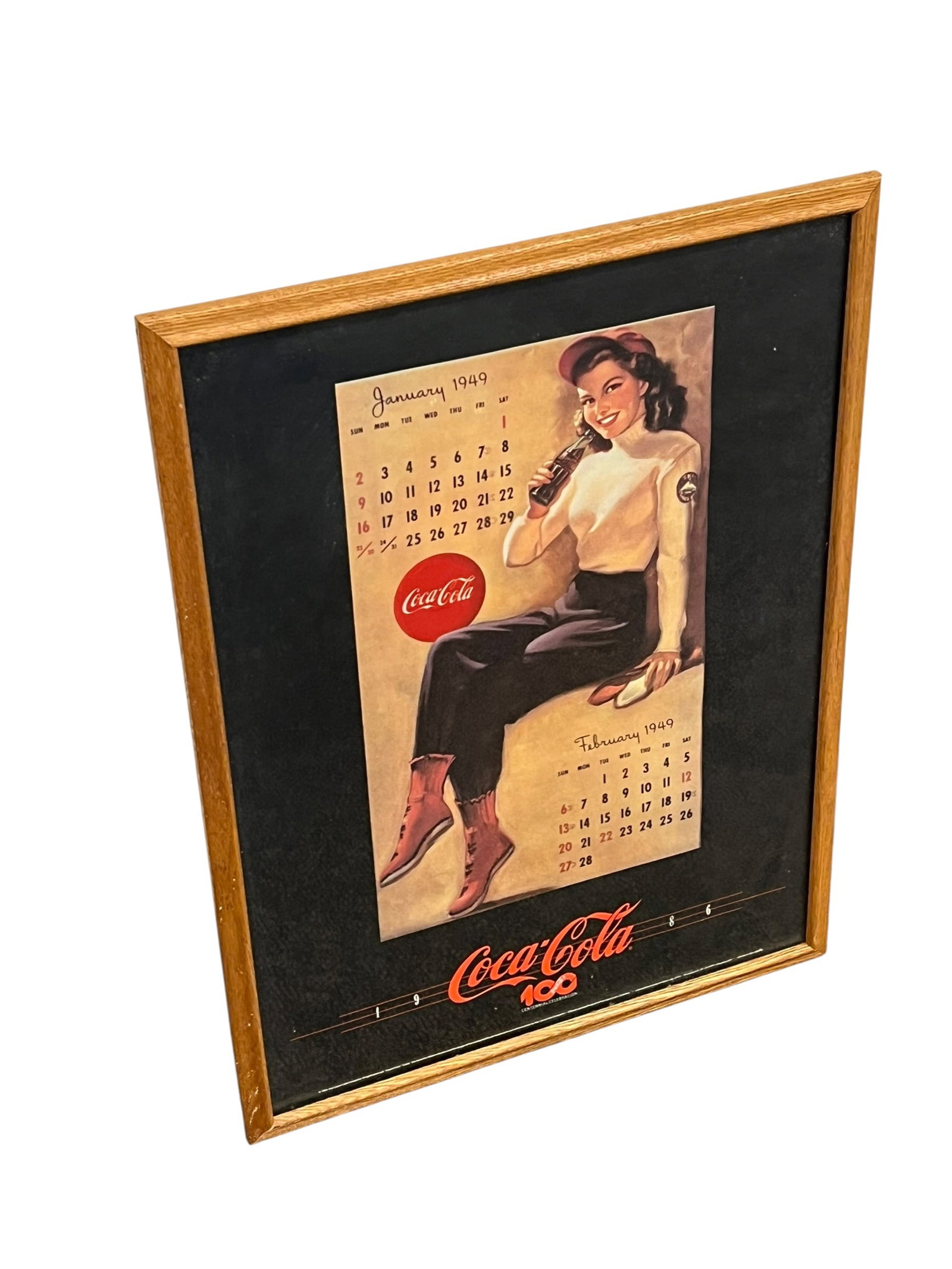 Coca Cola 1949 Calendar Advertising Poster: This framed vintage collectible is an original January/February 1949 Coca-Cola advertising calendar featuring pin-up artwork by renowned artist Gil Elvgren. [1, 2, 3]Artwork & Artist: The pin-up illus