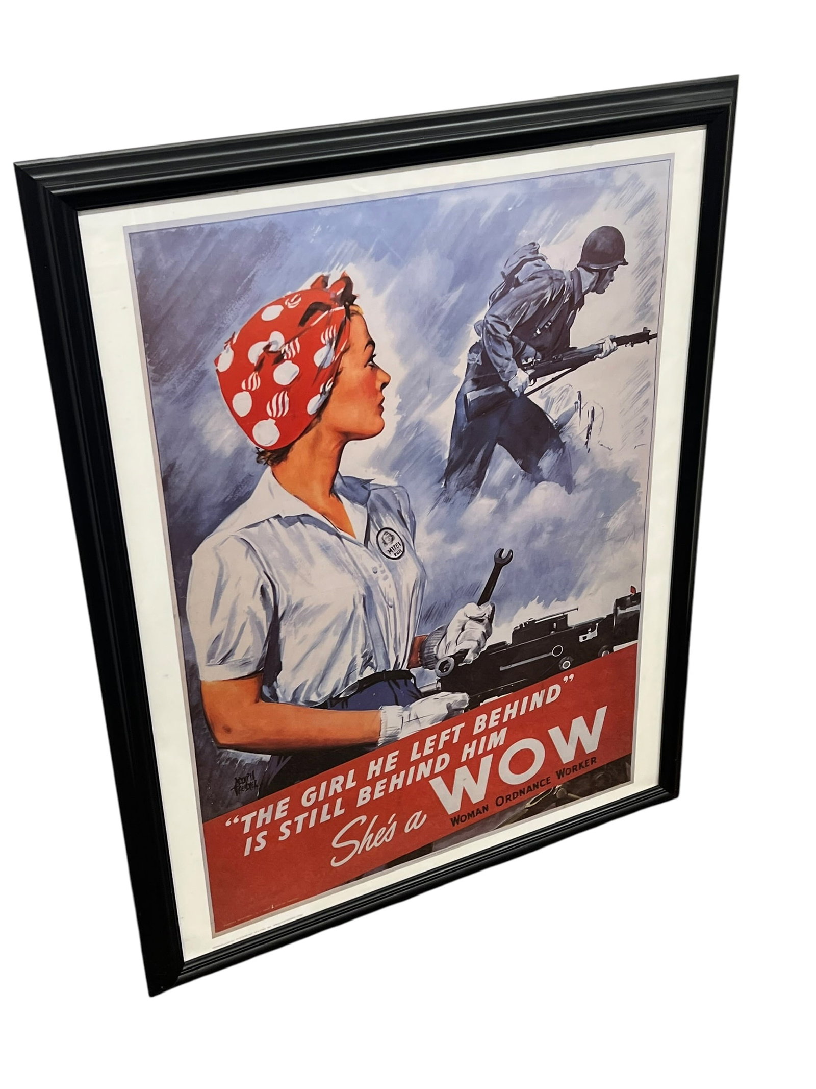The Girl He Left Behind Military Poster: Framed print of the 1943 World War II recruitment poster titled "The Girl He Left Behind Is Still Behind Him" — She's a WOW by artist Adolph Treidler. [1, 2, 3]Artwork Details: Created in 1943 by