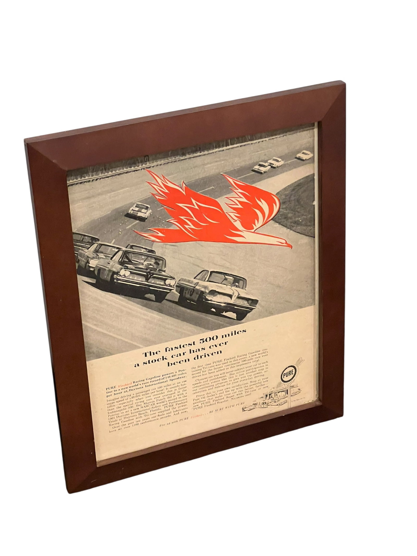 Pure Gasoline Advertising Poster: This framed vintage 1961 magazine advertisement for Pure Oil Firebird Racing Gasoline highlights NASCAR stock car racing at Daytona International Speedway. [1, 2, 3]Subject: Features a graphic red