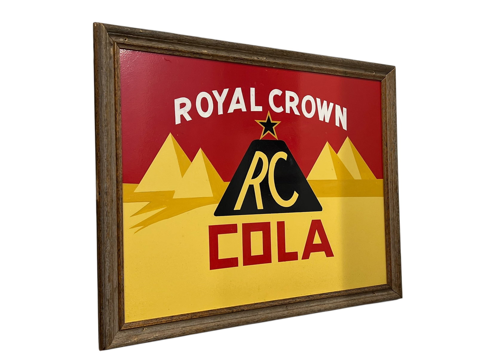 Royal Crown Cola Advertising Sign: This framed vintage-style Royal Crown RC Cola advertising sign features the iconic Egyptian pyramid graphic and bold retro lettering.Design Features: Displays "Royal Crown" arched across a red
