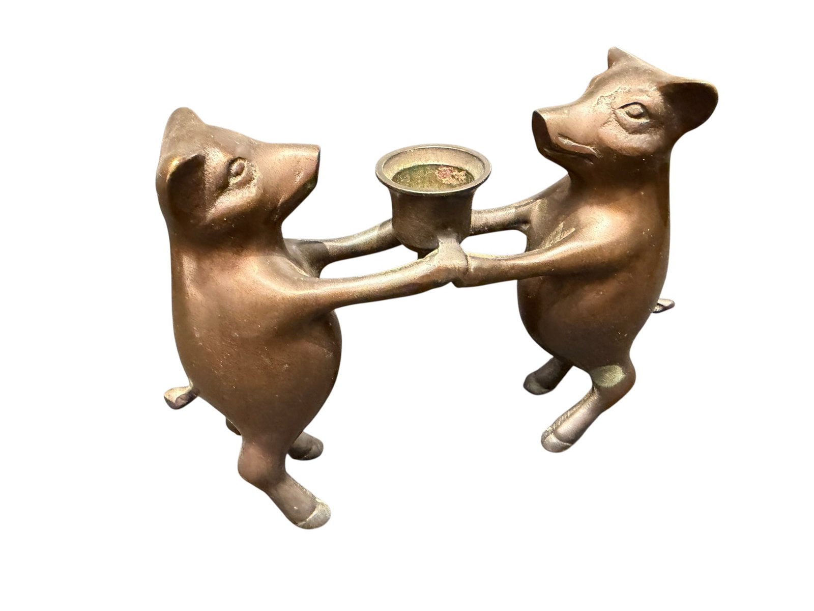 Bronze Candle Holder with Pigs: This is a charming vintage bronze or brass dancing pigs candle holder featuring two anthropomorphic hogs holding hands while supporting a central cup. [1, 2]Design: Whimsical figural piece depicting t