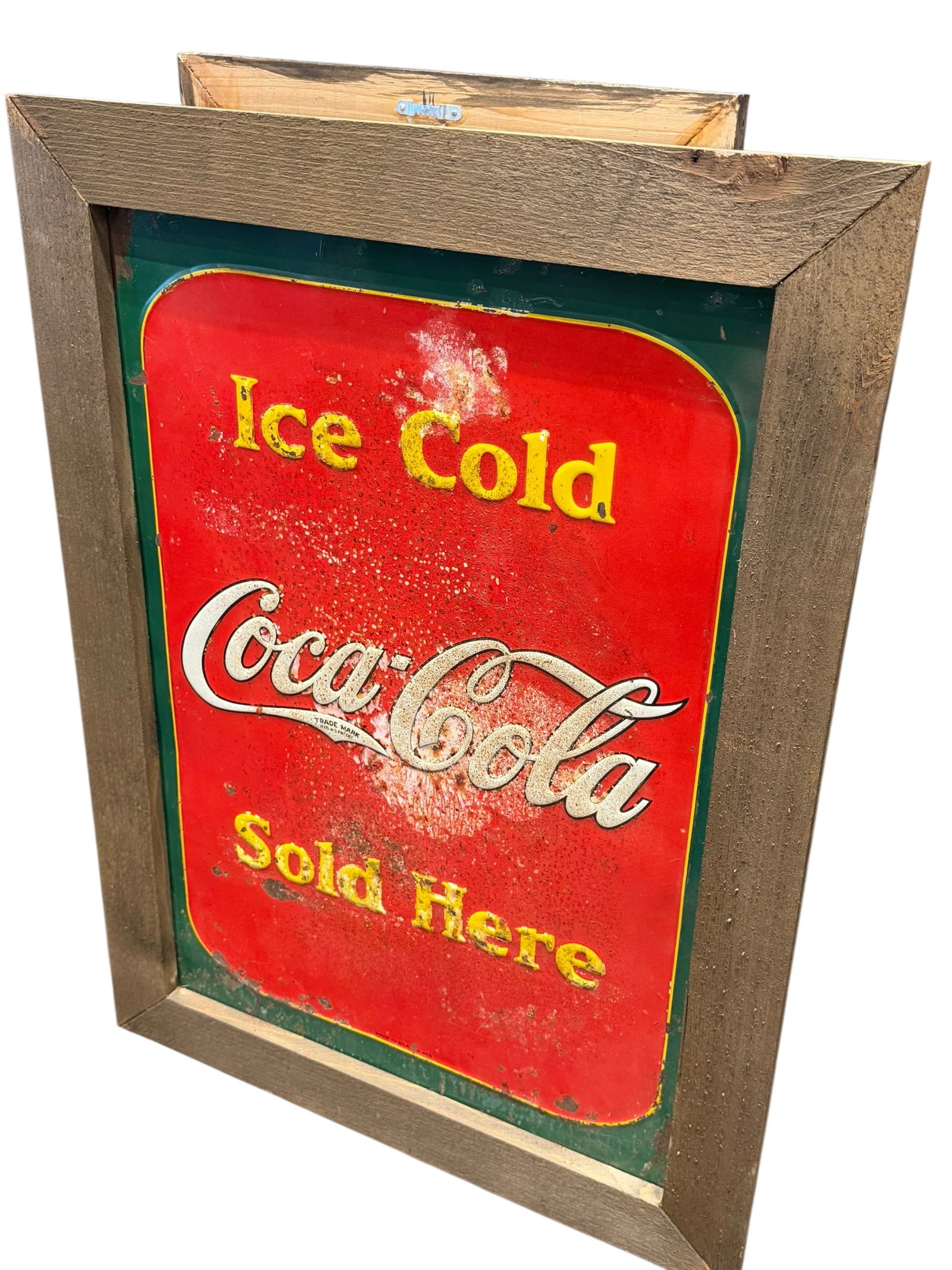 Early Coca Cola Advertising Sign in Frame: This item is "Ice Cold Coca-Cola Sold Here" metal tin sign featuring a rustic wooden frame. [1, 2]Design: Red and green background with yellow and white lettering reading "Ice Cold Coca-Cola Sold Here
