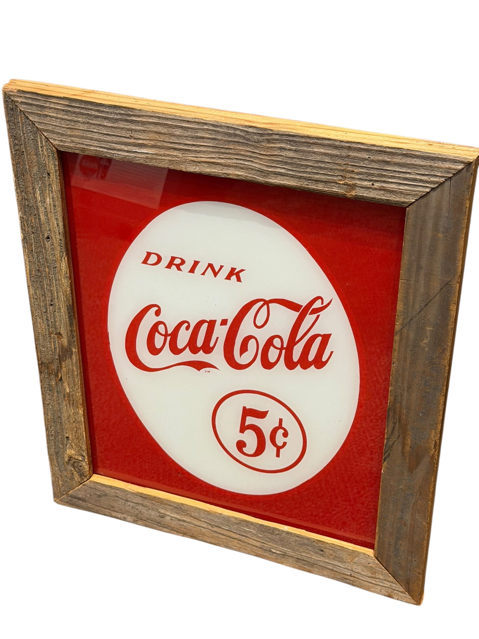 Early Coca Cola Advertising Sign in Frame: This image shows a vintage-style Coca-Cola advertising sign featuring the classic "Drink Coca-Cola 5¢" red-and-white button logo set inside a rustic, weathered wooden frame. [1]Design Features: Displ
