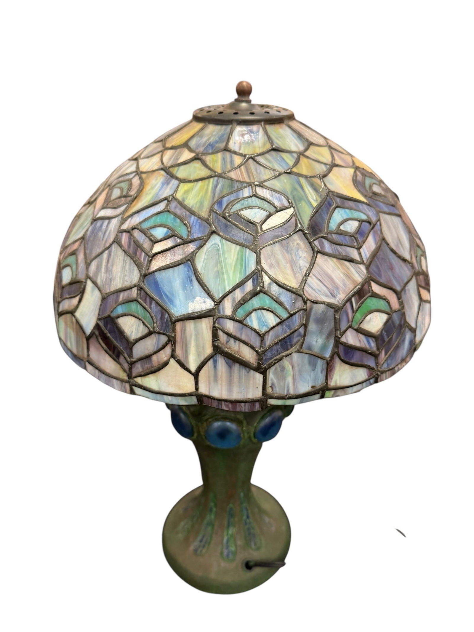 Slag Glass Lamp: This is a vintage Tiffany-style stained glass table lamp featuring a distinctive peacock feather pattern on the dome shade and a patinated green metal base adorned with blue glass cabochons. [1, 2,