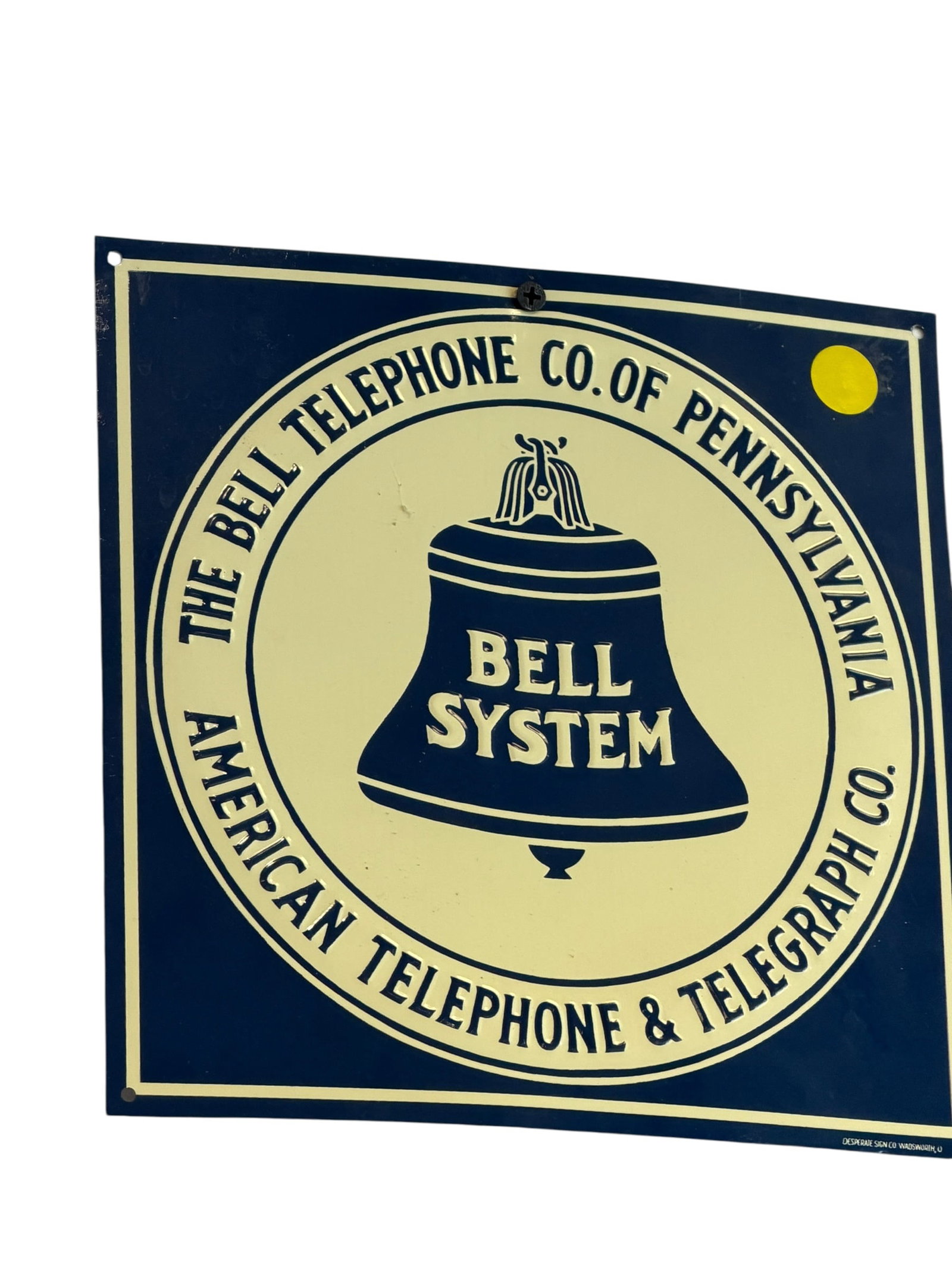 Bell System Telephone Co. Advertising Sign: This vintage-style square metal sign appears to be a replica or reproduction featuring the classic logo and text for The Bell Telephone Co. of Pennsylvania and American Telephone & Telegraph Co. [1, 2