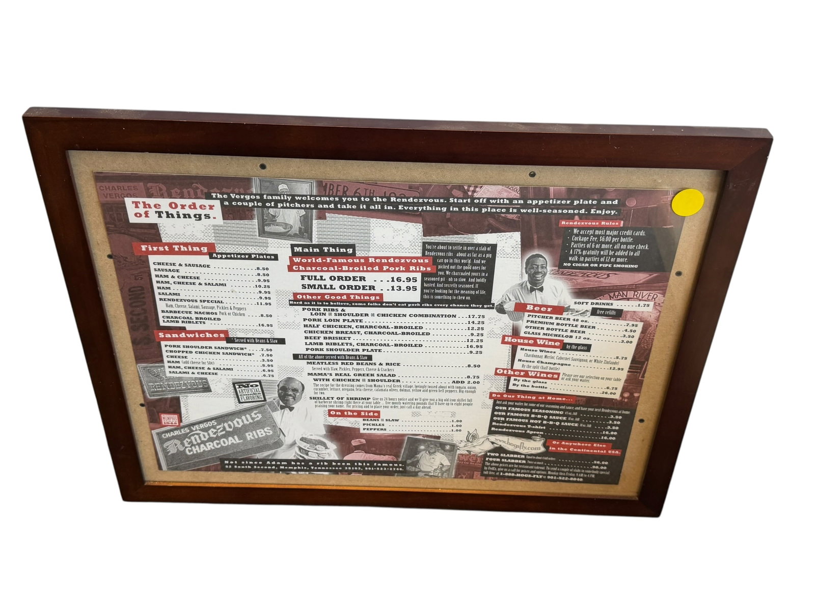 Framed Menu from Charlie Vergos’ Rendezvous: The framed item appears to be a vintage Charles Vergos' Rendezvous restaurant menu from Memphis, Tennessee, showcased behind glass in a wooden frame. [1, 2]Features the iconic layout and sections of