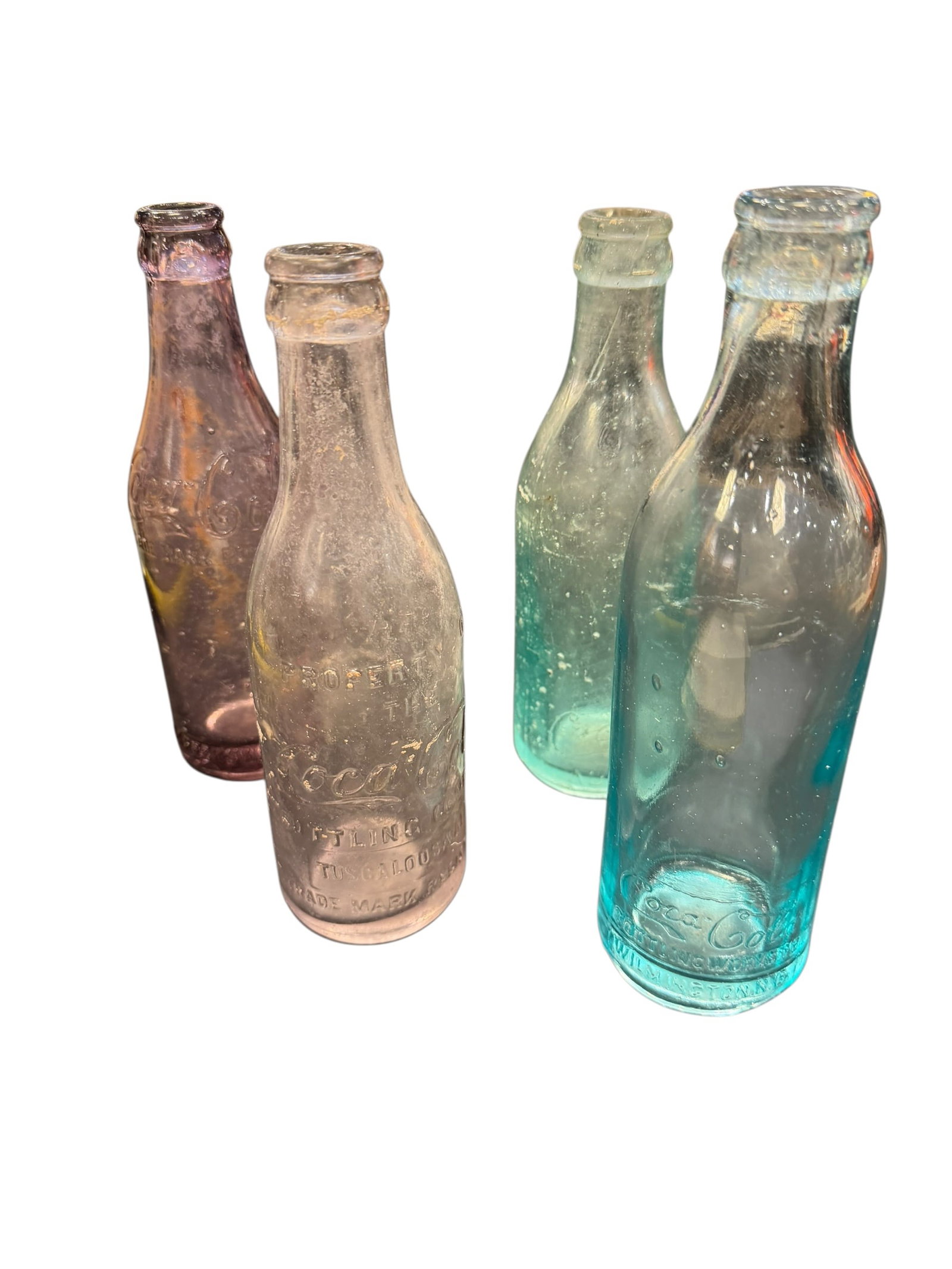 Lot of 4 Straight Side Coca Cola Bottles: The selected region displays a collection of four antique, straight-sided glass soda bottles, appearing to be vintage embossed Coca-Cola or similar early 20th-century soft drink bottles featuring