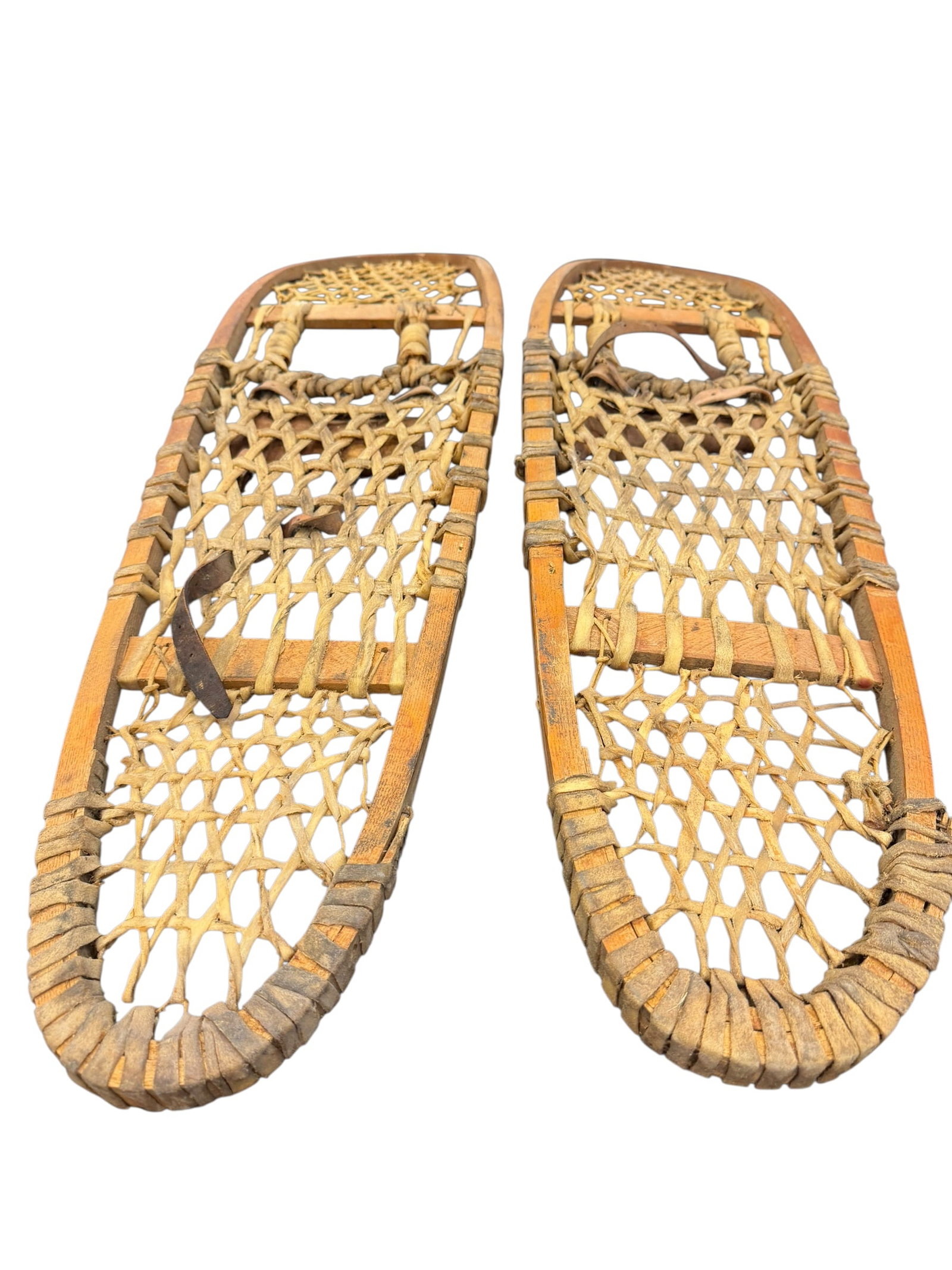 Pair of Snowshoes: The selected region appears to show a vintage pair of traditional wooden Bear Paw snowshoes featuring bentwood frames and woven rawhide lacing. [1, 2]Design: Compact, rounded shape traditionally used