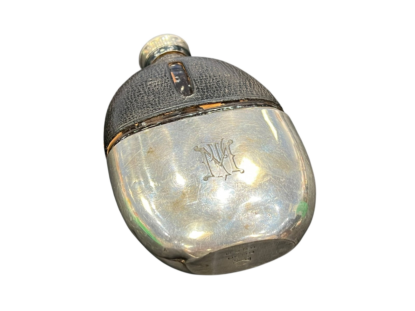 Leather Bound Flask: This object is an antique Victorian or Edwardian glass hip flask featuring a textured leather-bound upper body and a removable silver or silver-plated drinking cup. [1, 2, 3]Key Identification