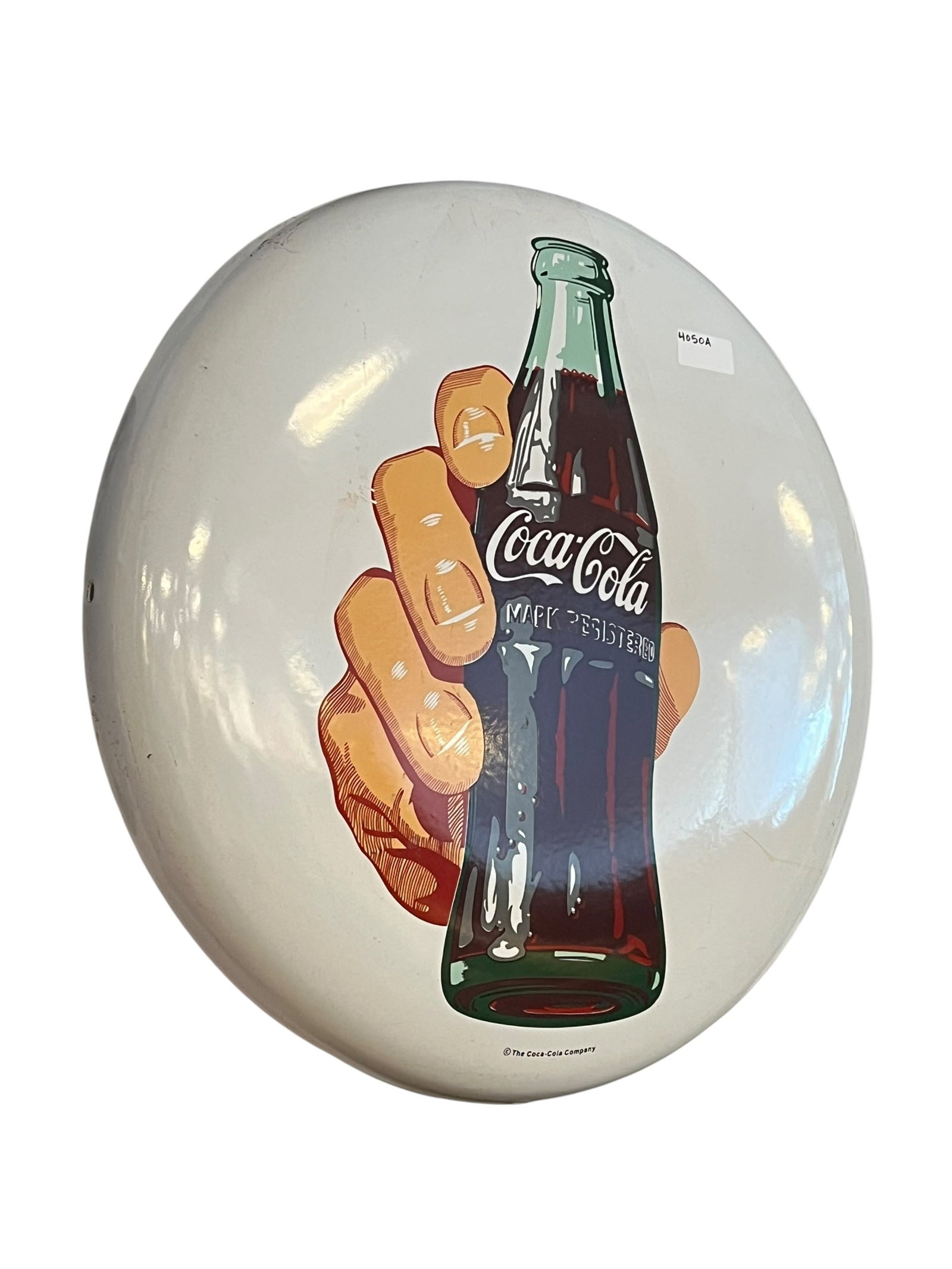 24" porcelain Coca Cola Button: This is a Coca-Cola porcelain button sign featuring the iconic imagery of a hand holding a classic contour glass bottle against a white background. [1, 2]About the SignEra: Originally introduced in th
