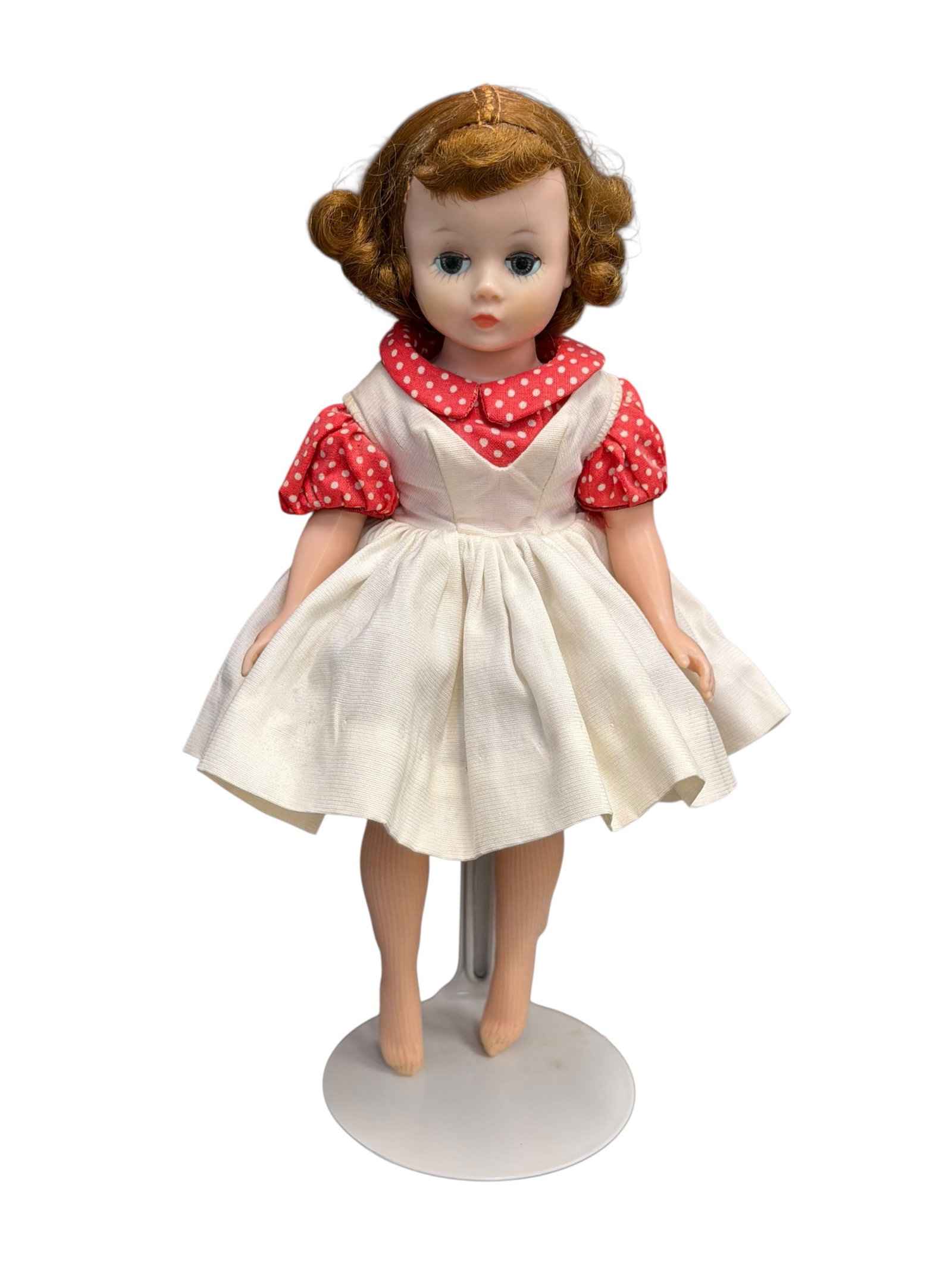 1950’s Vintage Madame Alexander Cissette Fashion Doll: This appears to be a vintage 1950s Madame Alexander Cissette hard plastic fashion doll wearing a classic red-and-white polka-dot and white pinafore dress outfit. [1, 2, 3]Key FeaturesMaker: Madame Ale