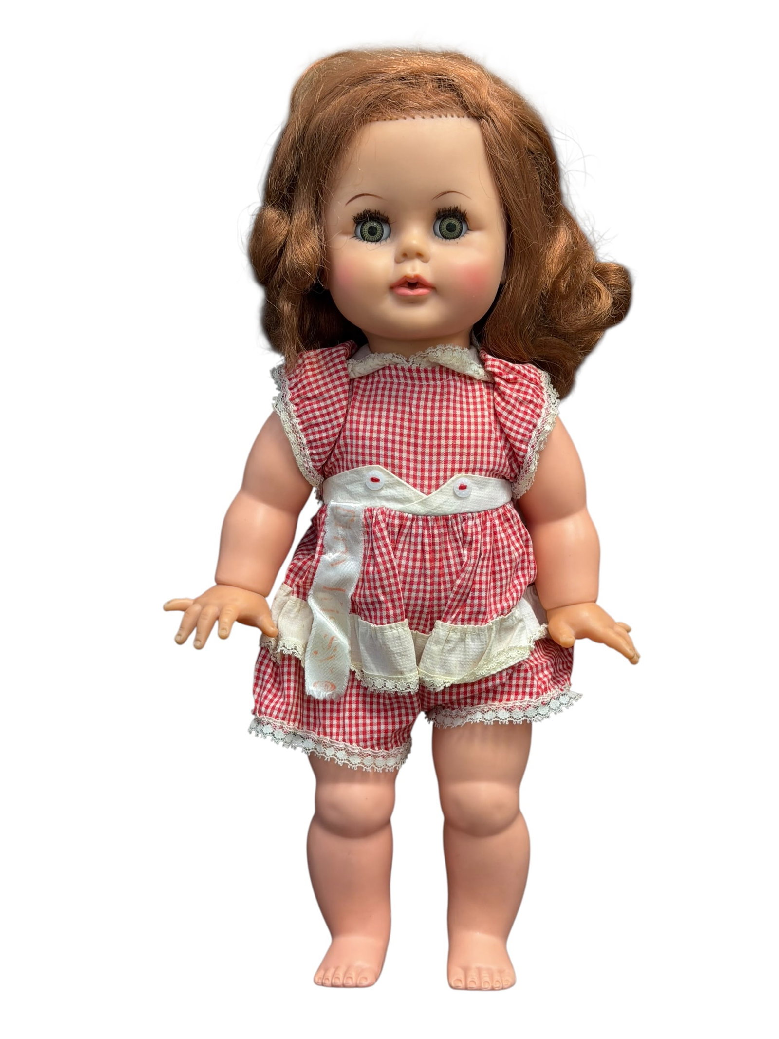 Ideal Vinyl Head Doll: vintage Ideal Kissy Doll from the 1960s, wearing a red-and-white checkered romper. [1, 2]Brand: Ideal Toy CorporationEra: 1960sFeature: Designed to pucker its lips when the arms move together