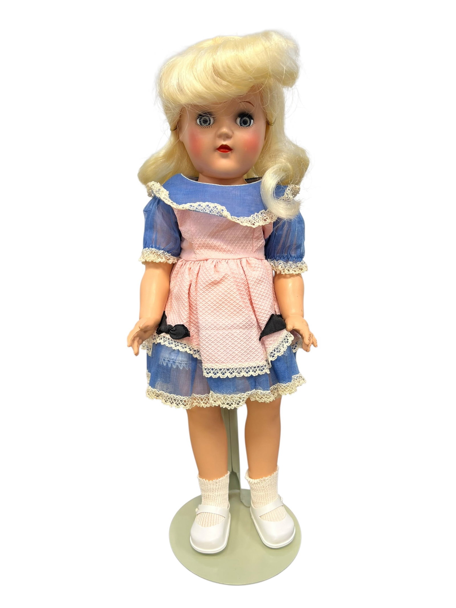Ideal Genuine Toni Doll: The doll is made of hard plastic, features blue sleep eyes, and wears a characteristic blonde nylon/dynel wig. This specific model is outfitted in a classic Alice in Wonderland style ensemble