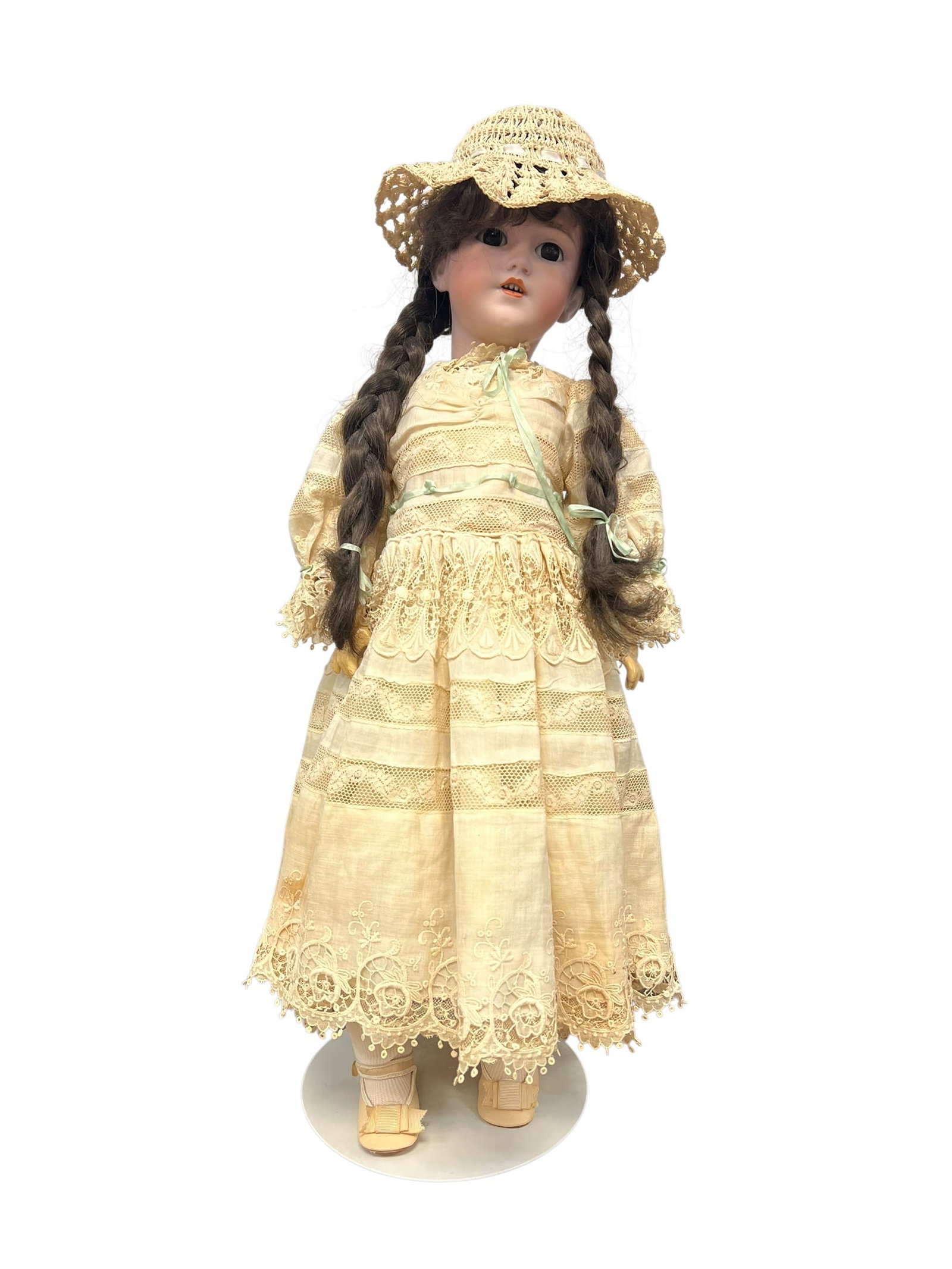Germany Halbig S&H 1249 Bisque Head Doll: antique German porcelain or bisque head doll with braided brown hair, wearing a pale yellow lace-trimmed dress and a matching straw bonnet.It appears to resemble late 19th- or early 20th-century