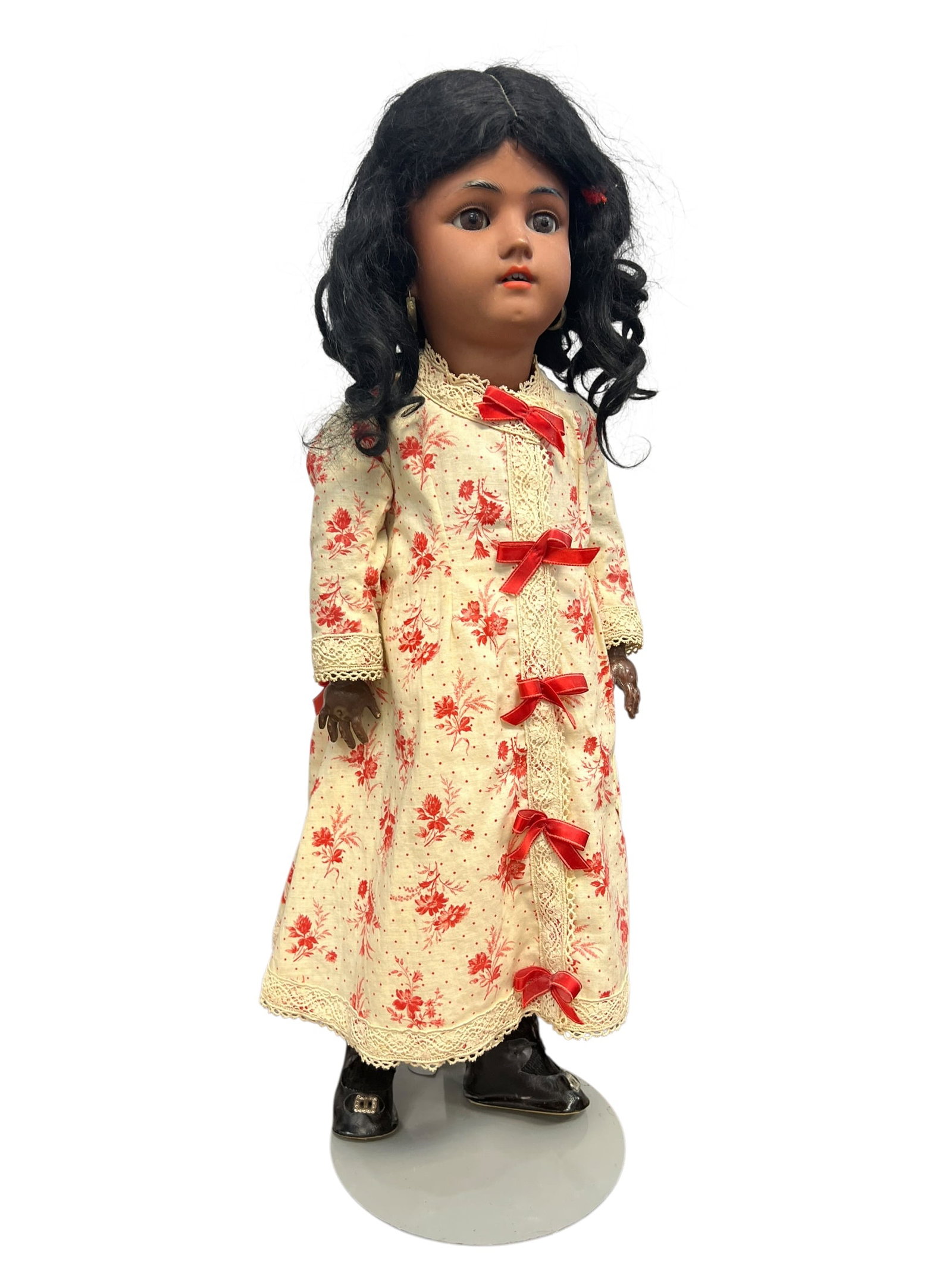Germany Heinrich Handwerck Bisque Head Doll: antique bisque-head doll with dark features, dressed in a cream and red floral dress with ribbon accents. [1, 2]Key FeaturesHead: Bisque porcelain with painted facial features and a dark complexion,