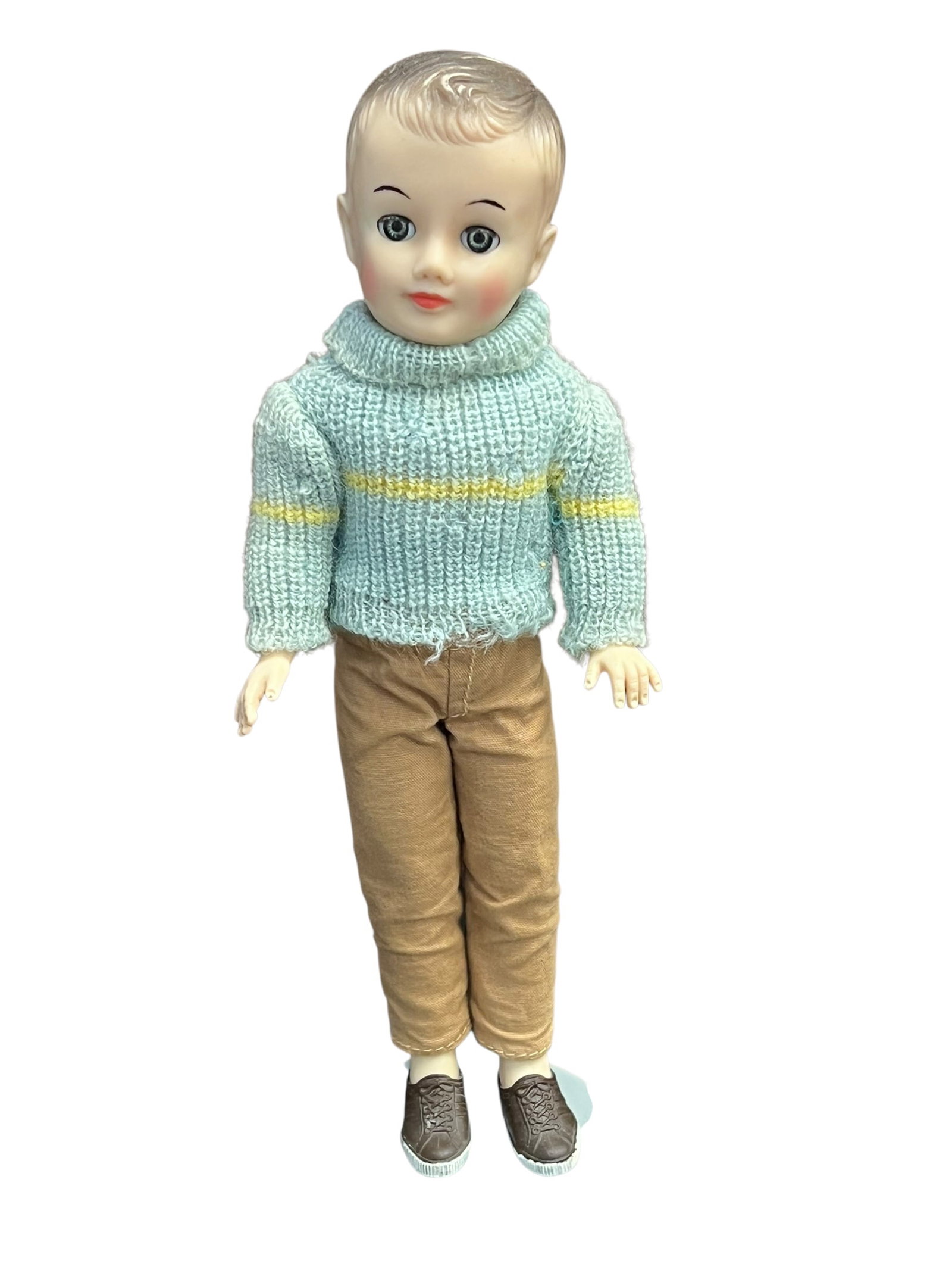 Vogue Vinyl Doll: vintage Vogue Jeff doll from the late 1950s, wearing a light blue knitted turtleneck sweater with yellow stripes, tan trousers, and shoes. [1, 2]Doll DetailsMaker: Vogue Dolls, Inc.Name: Jeff (Ginny's
