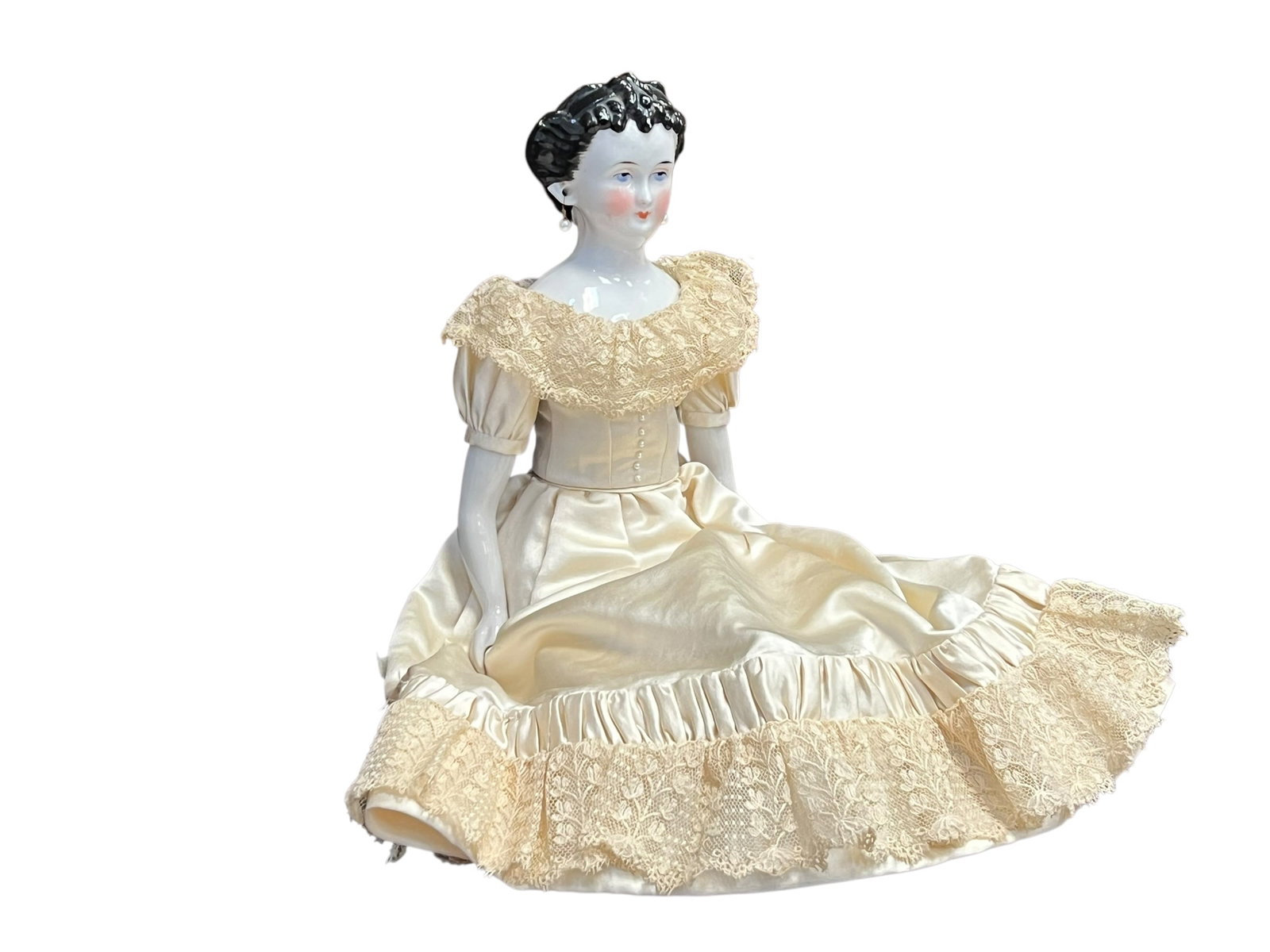 China Head Doll: antique or vintage porcelain/china-head or composition boudoir doll dressed in a cream-colored satin and lace gown. [1, 2, 3]Head: Features a glazed porcelain or ceramic-like glossy finish with