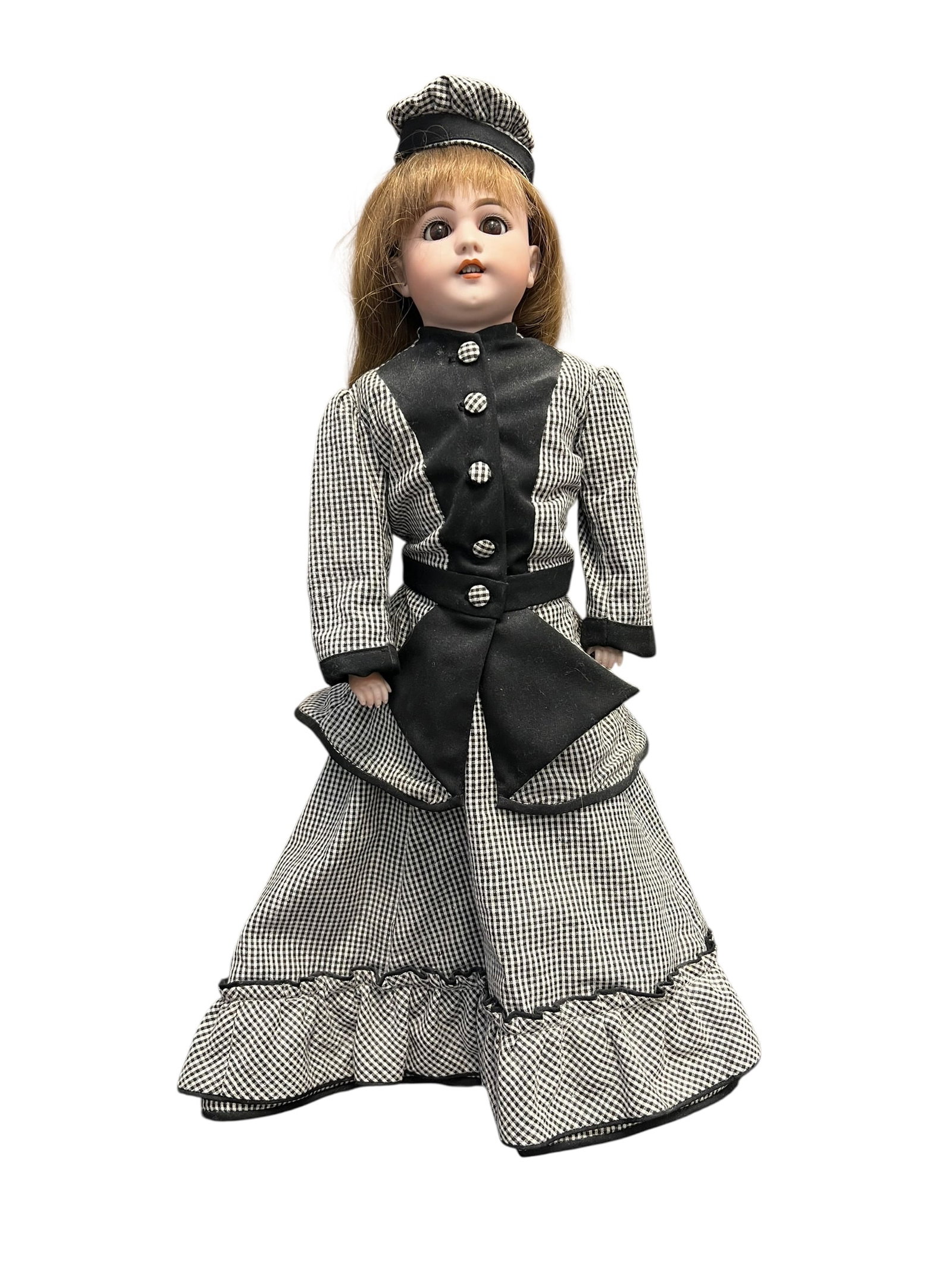 Bisque Head Doll: porcelain doll dressed in a Victorian-style walking suit. The ensemble showcases a black-and-white houndstooth or gingham pattern accenting a black buttoned bodice, paired with a matching tiered ruffl