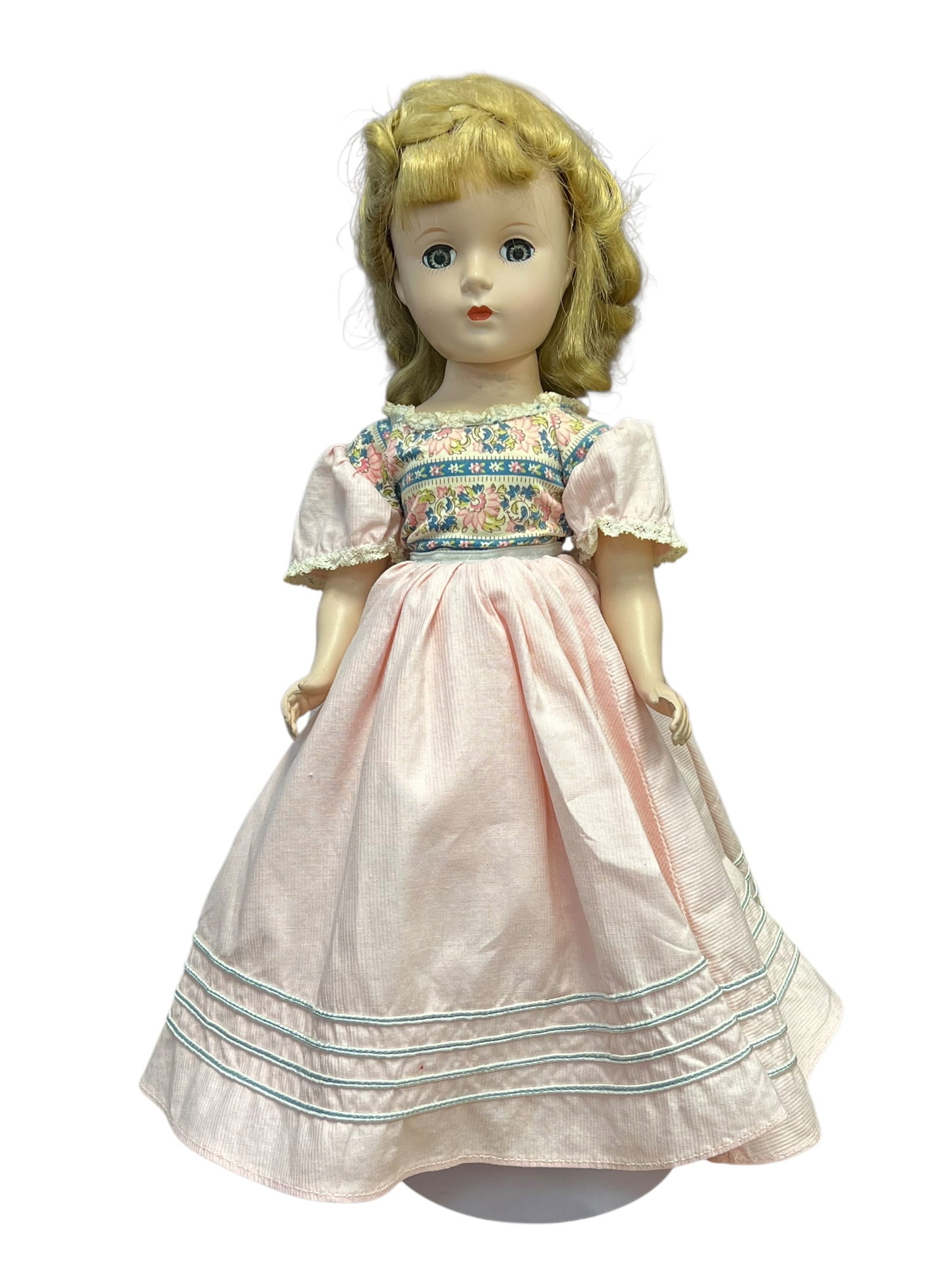 Plastic Doll: vintage 1950s hard-plastic "Little Women" Amy doll made by Madame Alexander. [1, 2]Key FeaturesFace and Hair: Features a classic sleep eye look with painted details and styled blonde hair.Outfit: