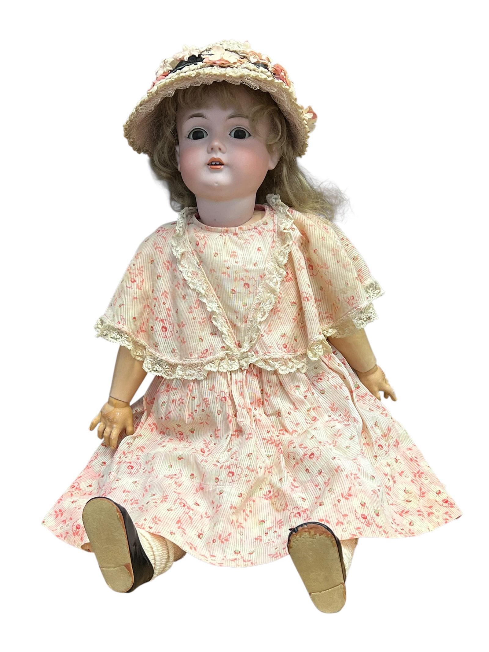 Germany Bisque Head Doll: antique German bisque-head doll from the late 19th or early 20th century, dressed in a vintage pink floral dress and matching bonnet. [1]Key FeaturesHead: Crafted from smooth bisque porcelain with