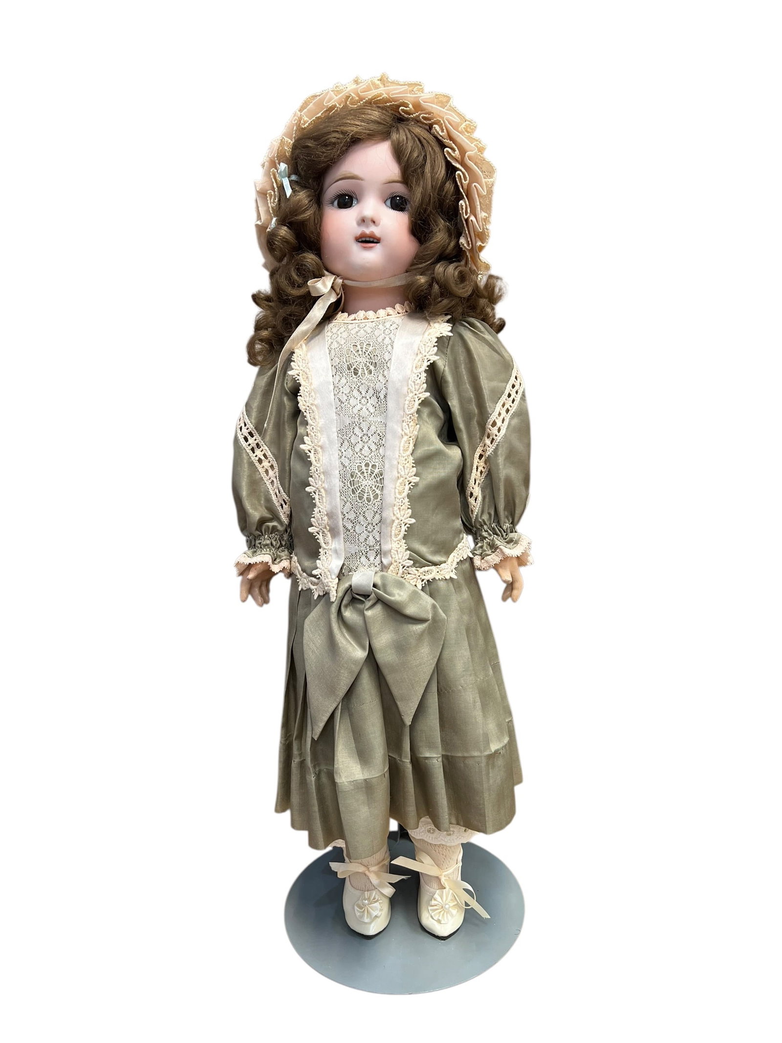 Eden Bebe Paris 9 Depose Doll: antique or reproduction French bisque porcelain Bébé-style doll dressed in an elaborate sage-green gown and matching ruffled bonnet. [1, 2]Key FeaturesHead and Face: Crafted from bisque porcelain
