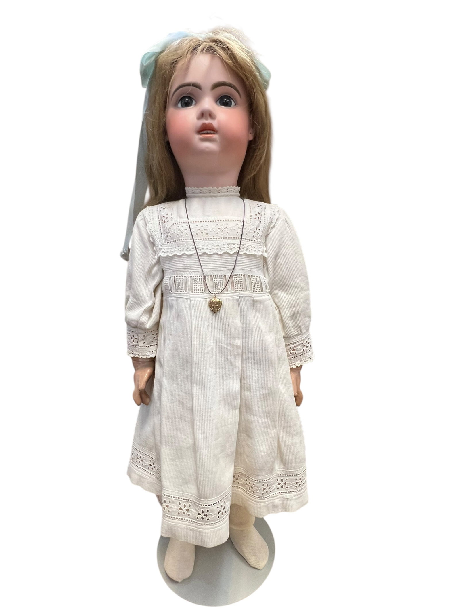 Tete Jumeau Bisque Head Doll: antique bisque-head doll wearing a white lace-trimmed dress and a light blue hair bow. [1]Key FeaturesHead: Appears to be crafted from smooth bisque porcelain with hand-painted facial features and