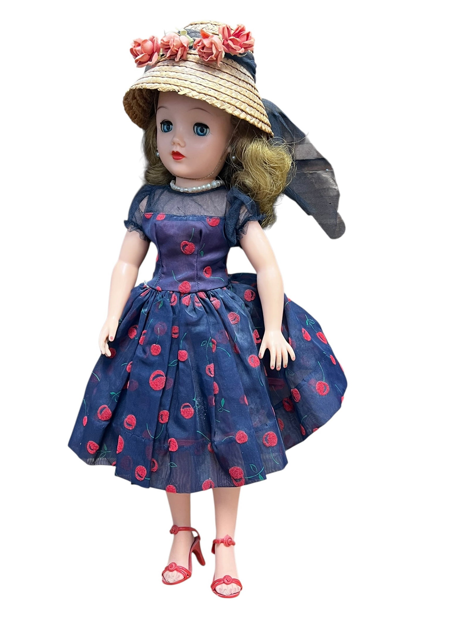 Ideal VT-18 Vinyl Doll: This is a vintage Ideal Miss Revlon fashion doll from the late 1950s wearing the "Cherries a la Mode" outfit. [1, 2]Key FeaturesMaker: Ideal Toy Corporation.Outfit: A navy blue sheer dress with a red