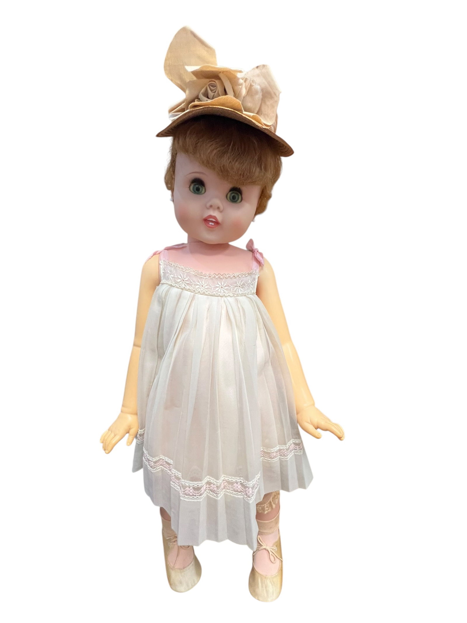 American Doll Toy Vinyl Doll: vintage 1960 American Character "Toodles" walking doll featuring signature peek-a-boo eyes, rooted auburn hair, and an original white dress with lace trim and a matching hat